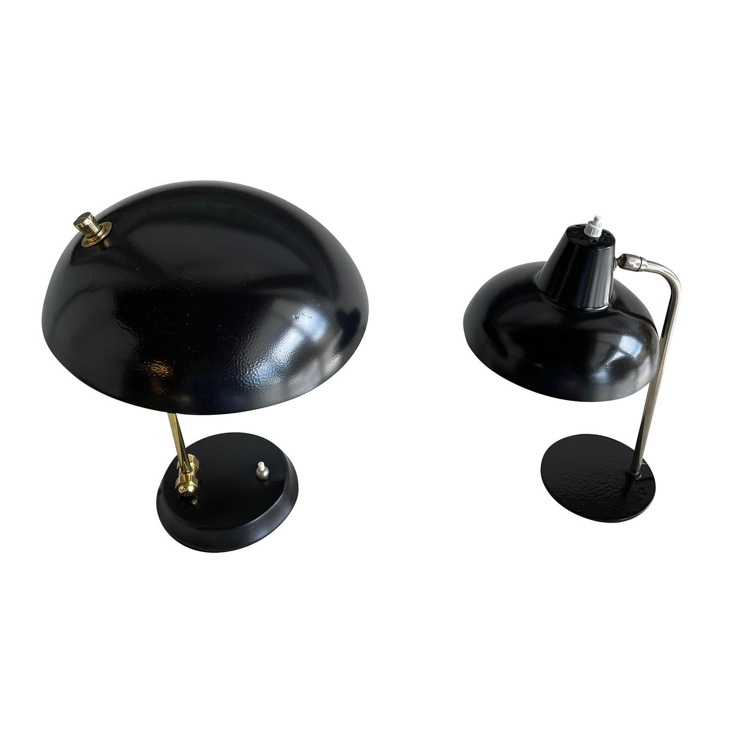 A black, vintage Mid-Century Modern Italian pair of similar table lamps made of hand crafted painted metal, in good condition. The neck of the smaller desk light is made of hand crafted steel, supported by a round metal base and the larger one is