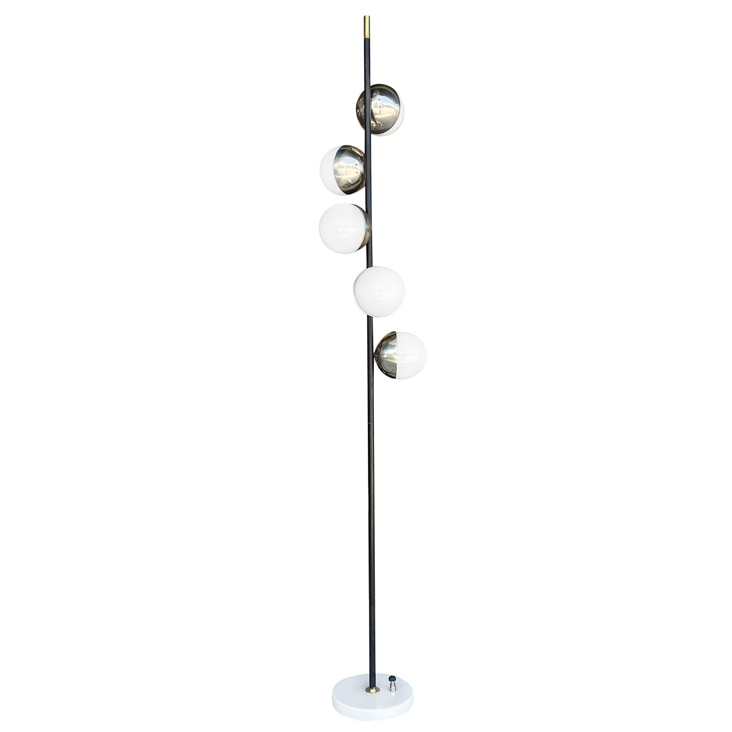 A vintage Mid-Century Modern Italian floor lamp made of hand crafted metal and brass, designed and produced by Stilnovo, in good condition. The floor lamp is composed with five round perforate chrome, frosted opaline glass shades, supported by a