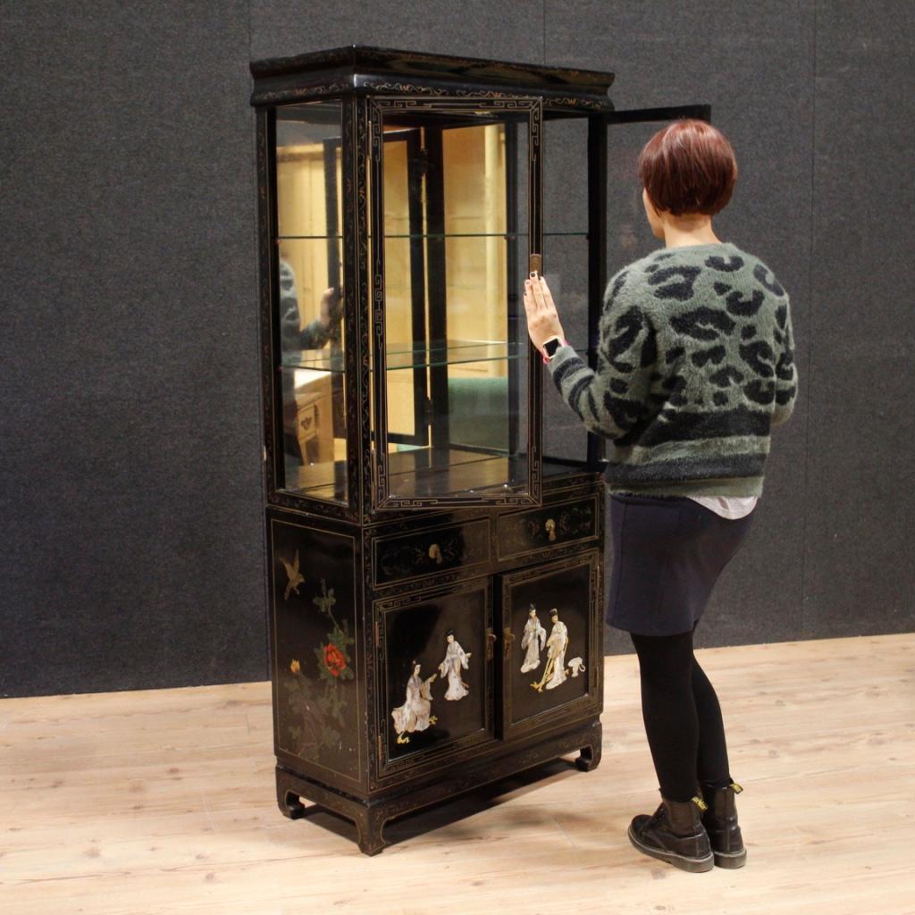 French display cabinet from 20th century. Furniture in lacquered, painted wood adorned with high-relief chinoiserie figures in soapstone. Double body showcase with two doors in the upper part, interior complete with two glass shelves and internal