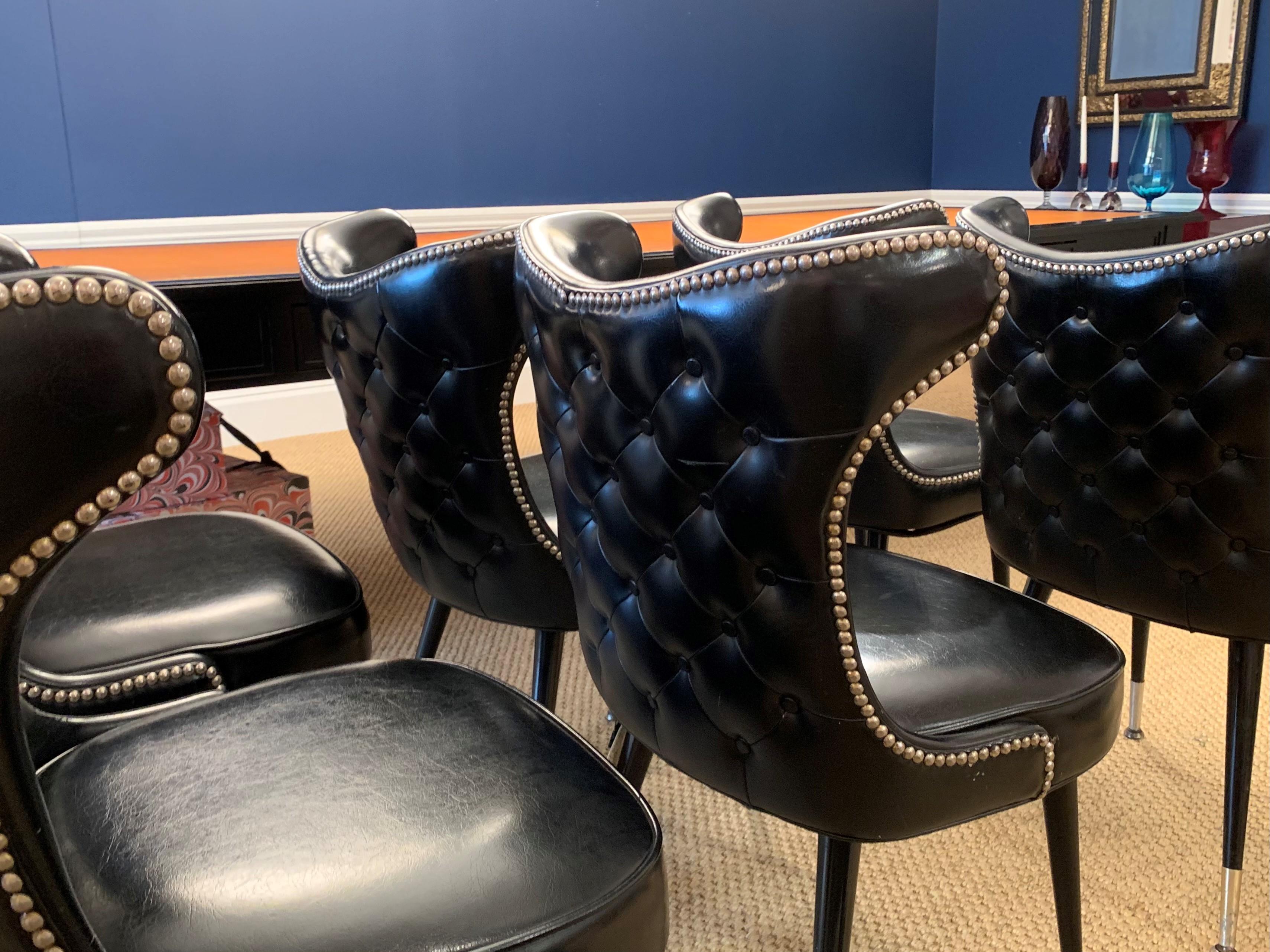 A lovely set of six vintage leather chairs with chrome studs, sabots and tufted backs.