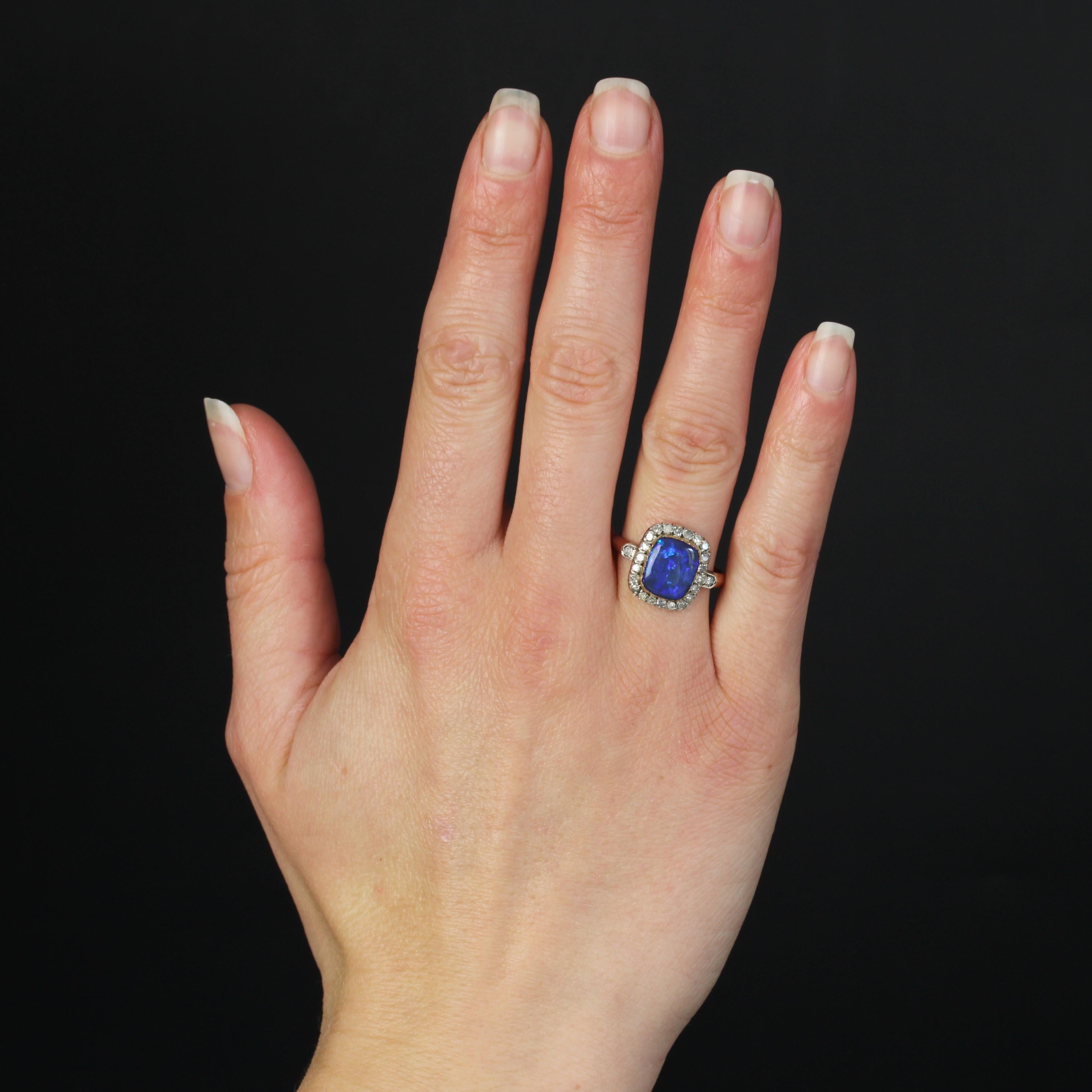 Ring in 18 karat rose gold, eagle head hallmark and silver.
This elegant antique ring holds a noble black opal with vivid blue-violet hues in a closed setting. A surround of antique-cut diamonds illuminates the setting. On either side of the head,