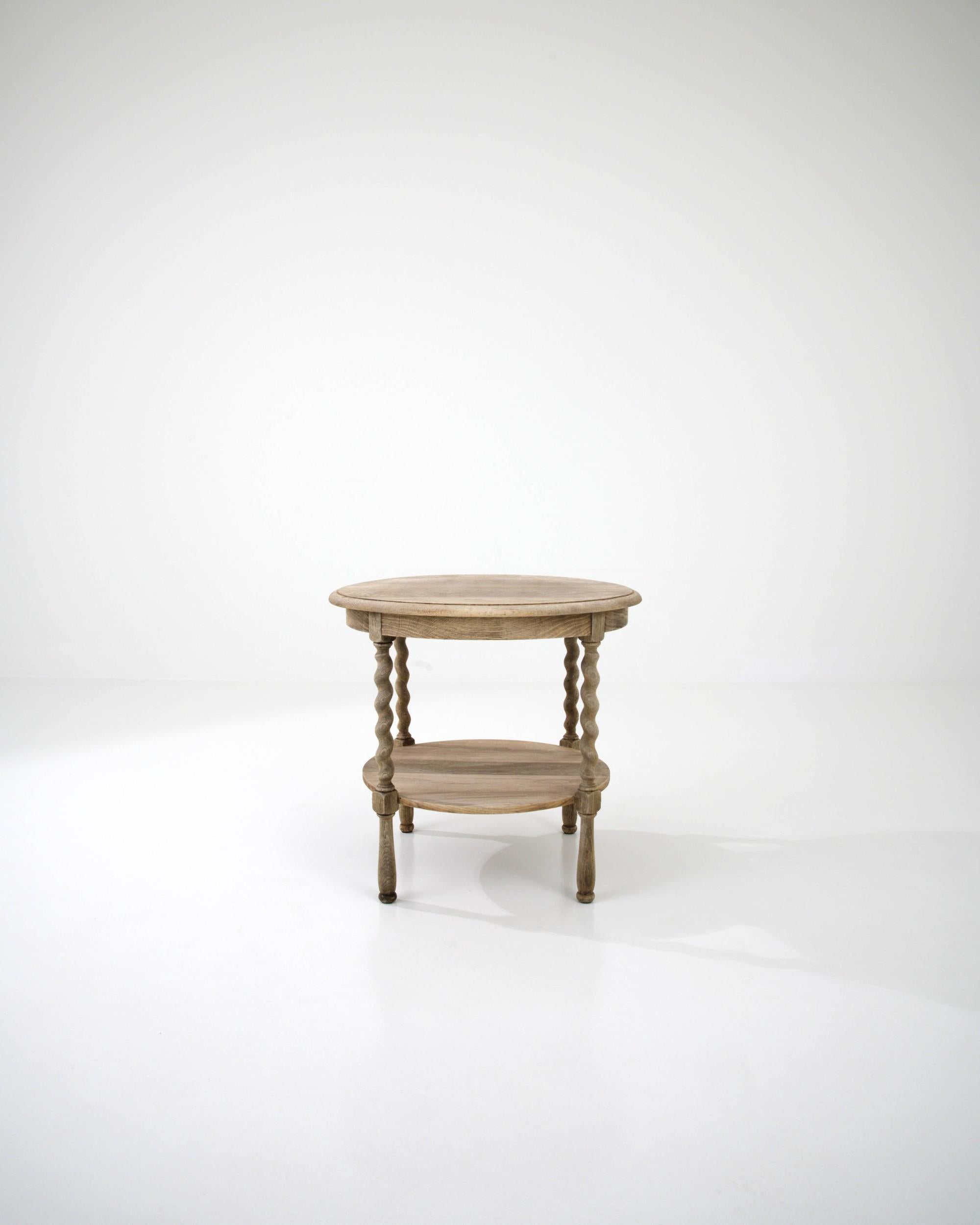 Made in Belgium in the 20th Century, this oak side table is defined by the shape of its round table top. The subtle organic feel of the ovoid top is enhanced by the table's finish and its barley twist legs. Natural oak has been enhanced with a