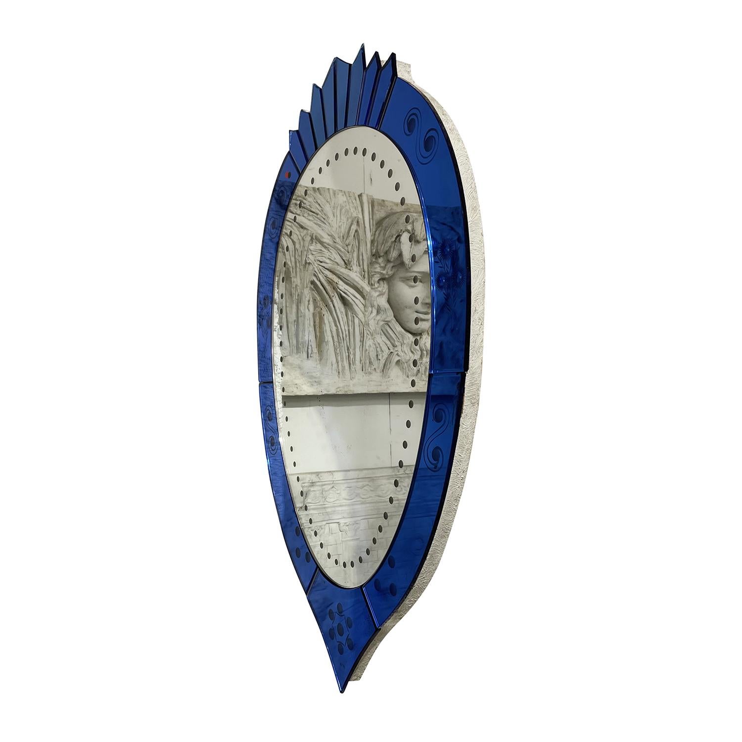 A dark-blue, vintage Mid-Century Modern Italian wall mirror made of hand blown cut crystal glass with its original colorful mirror glass, produced by Cristal Art in good condition. The wall décor piece is enhanced by detailed glass art,