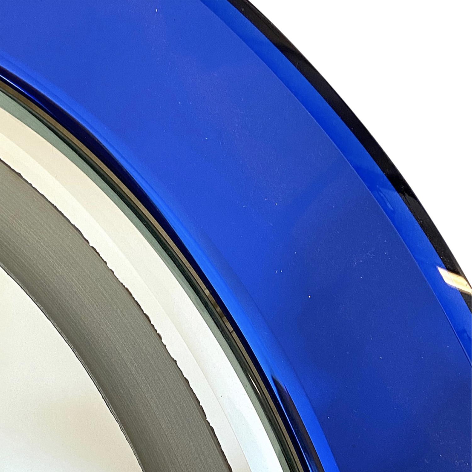 Miroir mural italien vintage du milieu du siècle, bleu foncé, en cristal taillé soufflé à la main, avec son verre miroir coloré d'origine, produit par Cristal Art, en bon état. Le miroir mural éclairé légèrement fumé est composé d'une douille à huit