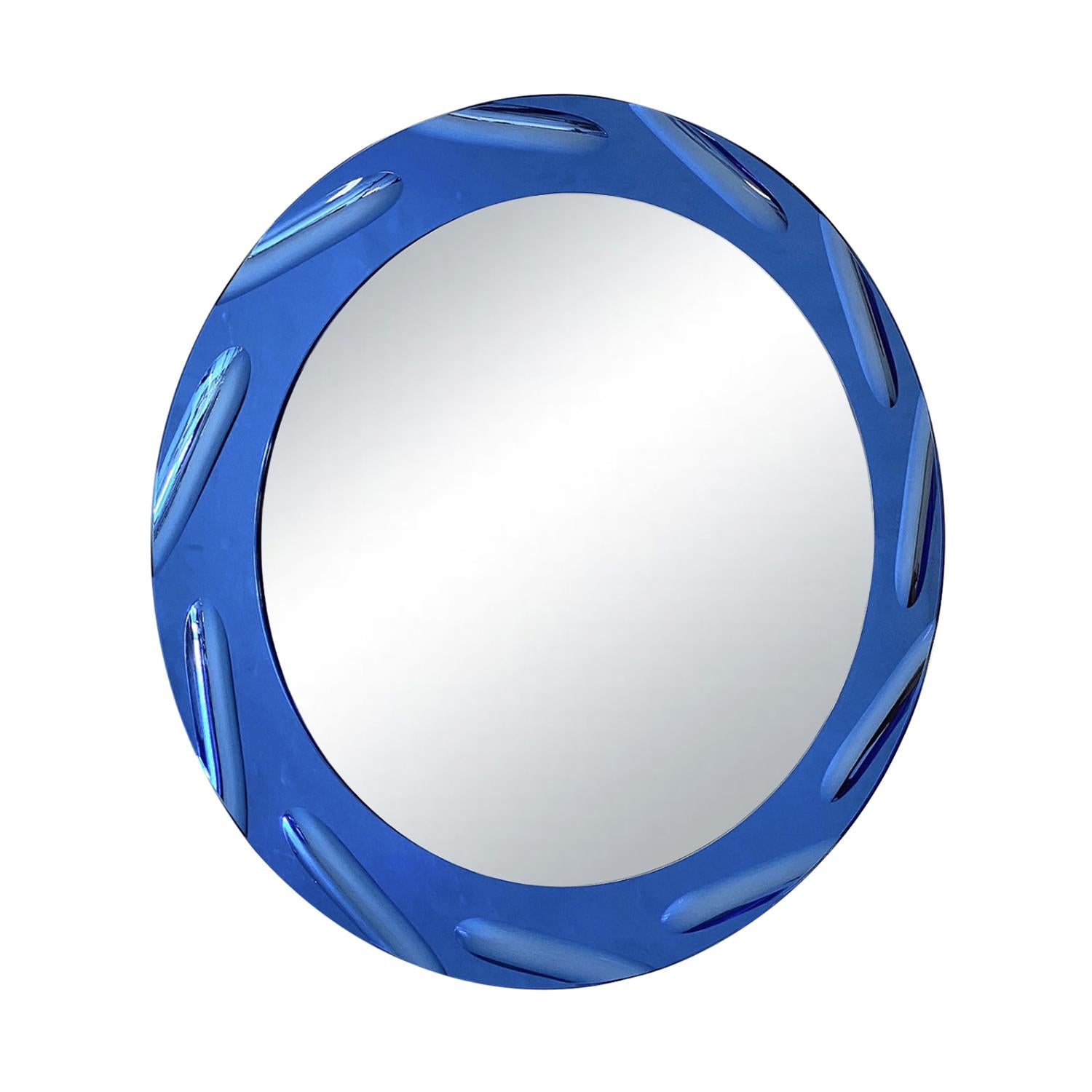 A dark-blue, vintage Mid-Century Modern Italian wall mirror made of hand blown cut crystal glass with its original colorful mirror glass, produced by Cristal Art in good condition. The round décor piece is enhanced by detailed glass art. Wear