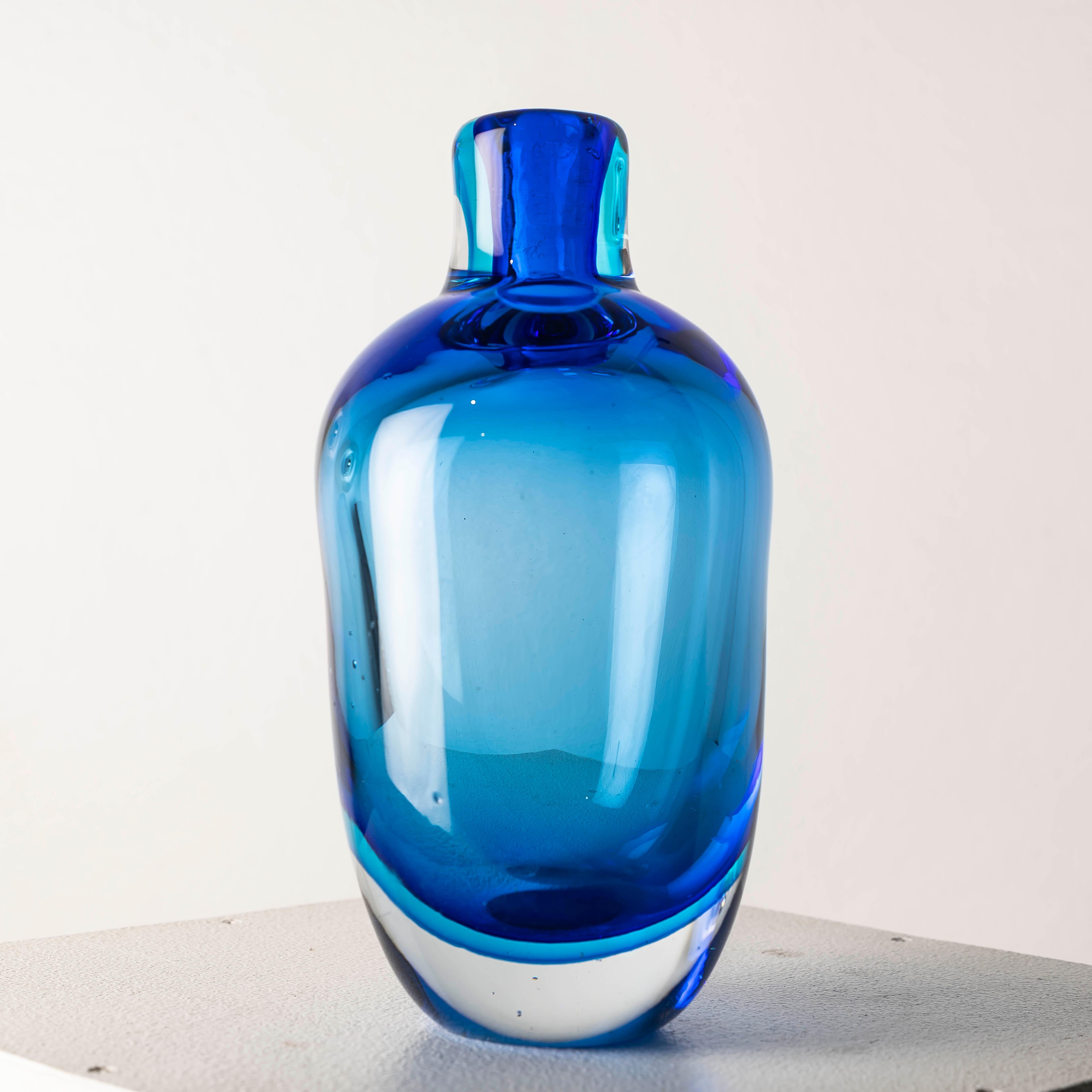 Questo vaso in vetro blu Sommerso del XX secolo è un esempio straordinario di arte vetraria italiana, caratterizzato dall'iconica tecnica del sommerso che crea un ipnotico effetto a strati nel vetro. Con la sua ricca tonalità di blu e l'impeccabile