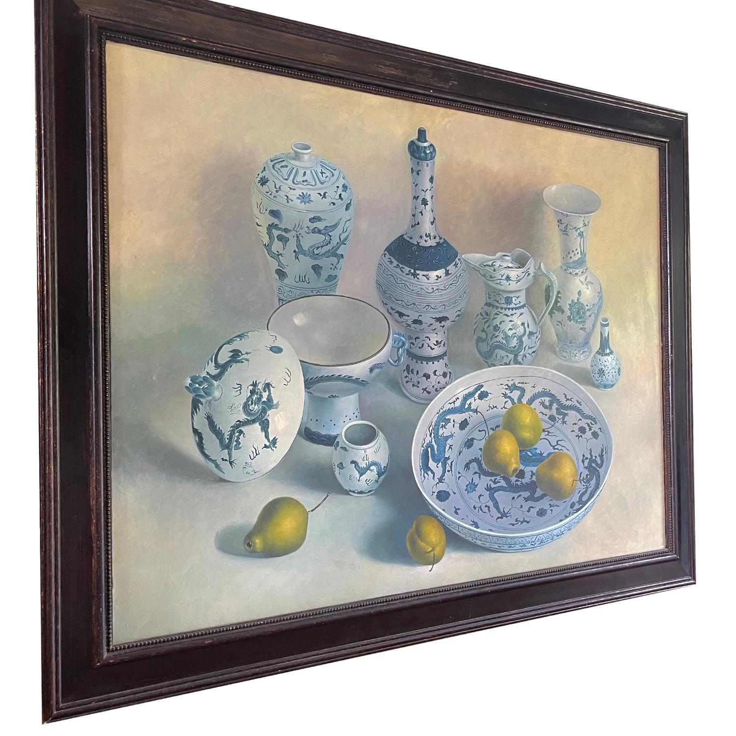 A blue-white, Mid-Century Modern still life oil on canvas painting, portraying a set of antique ceramic dishes with fruits on a large dining table, painted by an unknown painter from Europe in a hand carved original wooden frame, in good condition.
