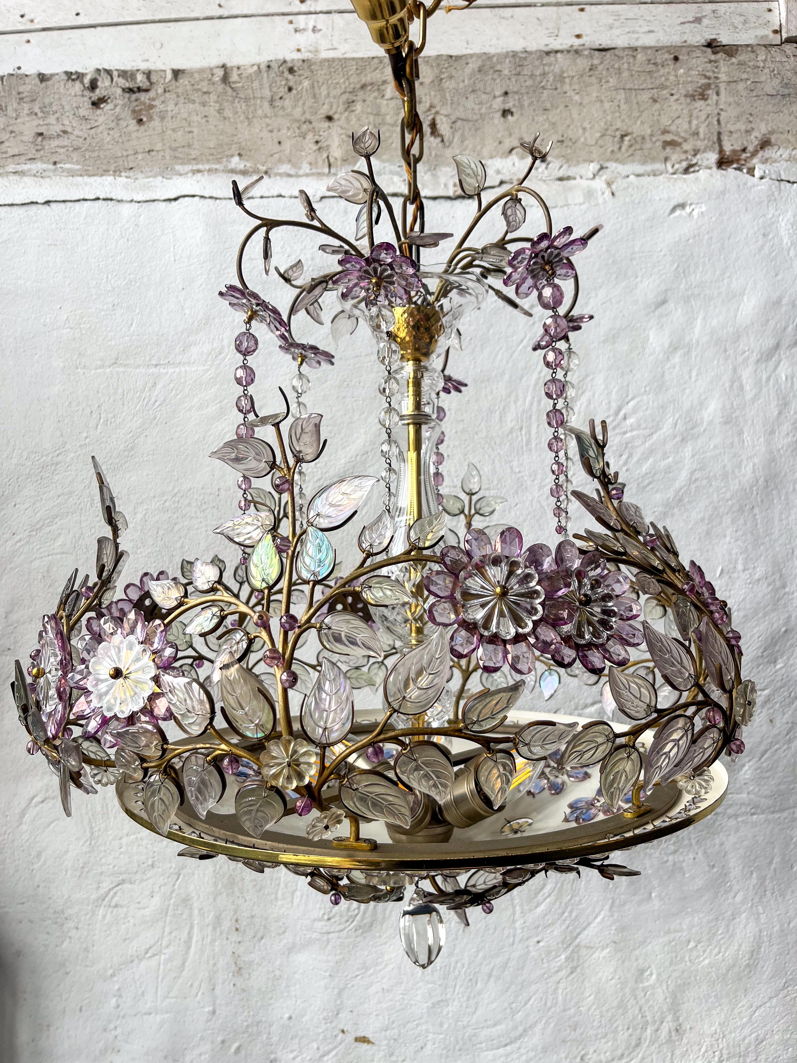 A very beautiful and ornate French polished brass chandelier, by Maison Bagues of Paris It is made up of a polished brass base with inlayed crystal droplets and brass branches with coloured  glass petal. The central stem of the chandelier adorned