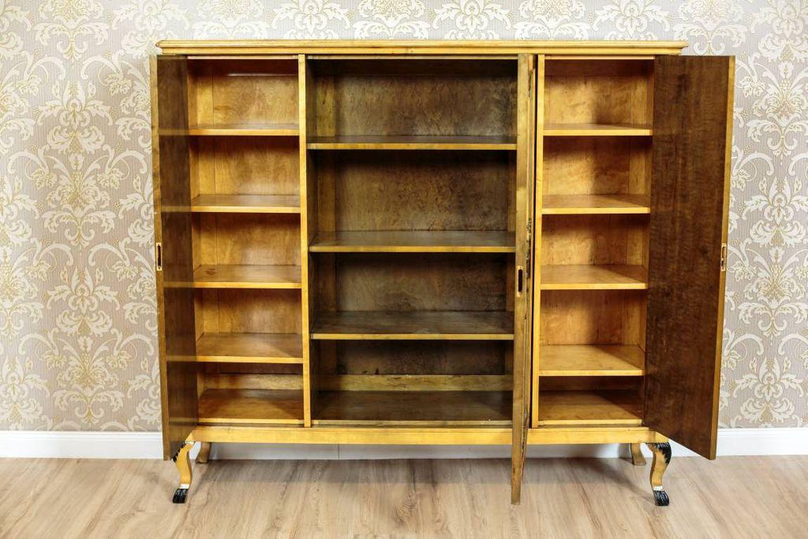 We present you a bookcase from the second half of the 20th century, veneered with birch and burl.
This piece of furniture is three-door on, and placed on bent legs.
The central part is wider, glazed. The side parts are narrower, with full