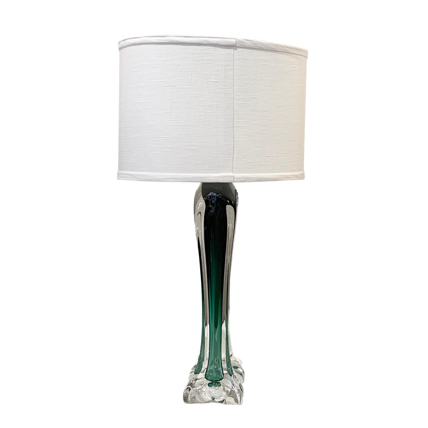 A vintage Mid-Century Modern Swedish table lamp made of dark green, white Orrefors glass, enhanced by very detailed decoration, in good condition. The desk lamp was produced by Flygsfors and signed below the square base, featuring a one light