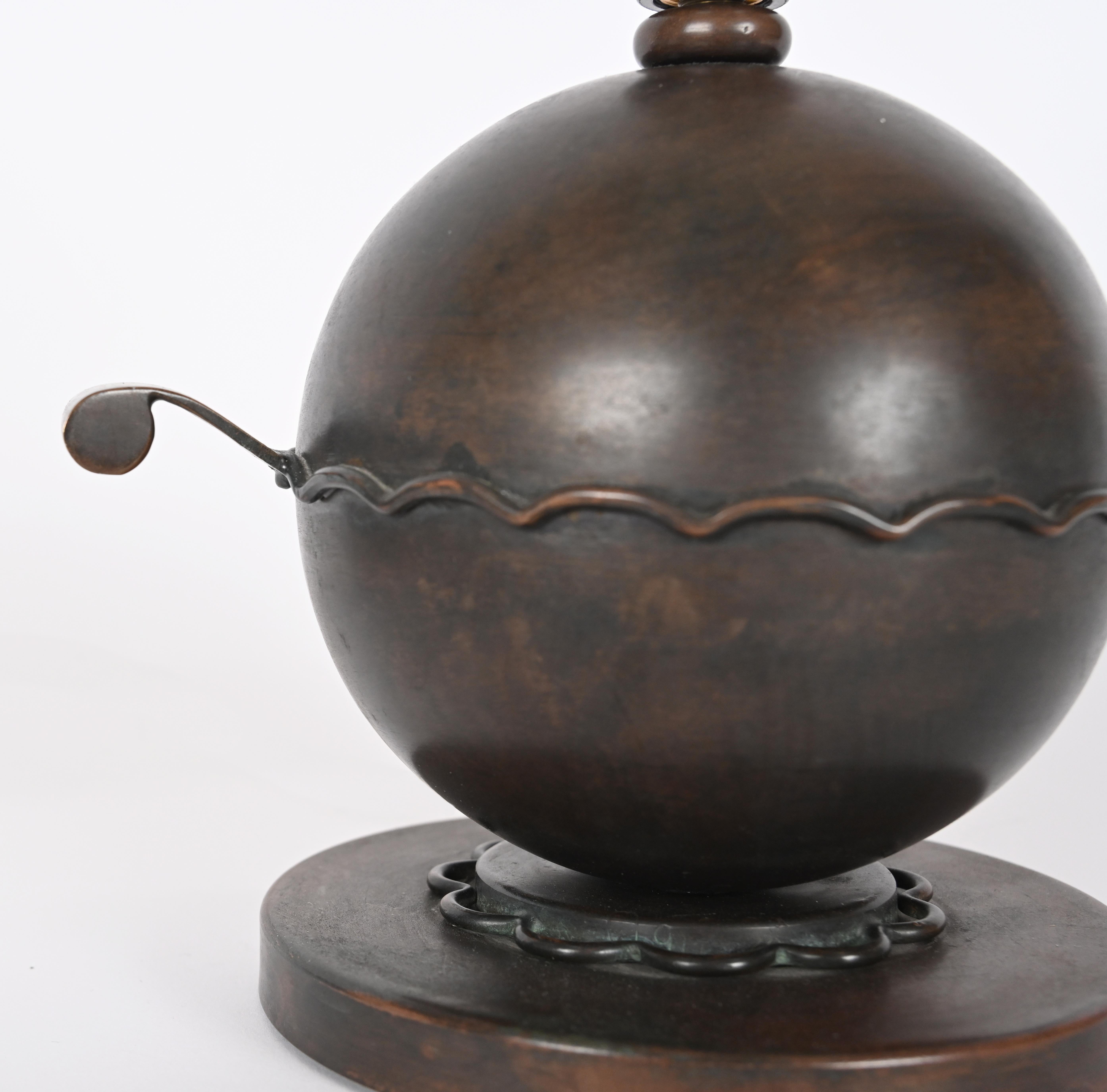 Circa early 20th Century. A spherical lamp design with curved line designs around the equator and inner ring of the base. The globe has two handles extending out with minimal rust along the surface.

Base Height: 7