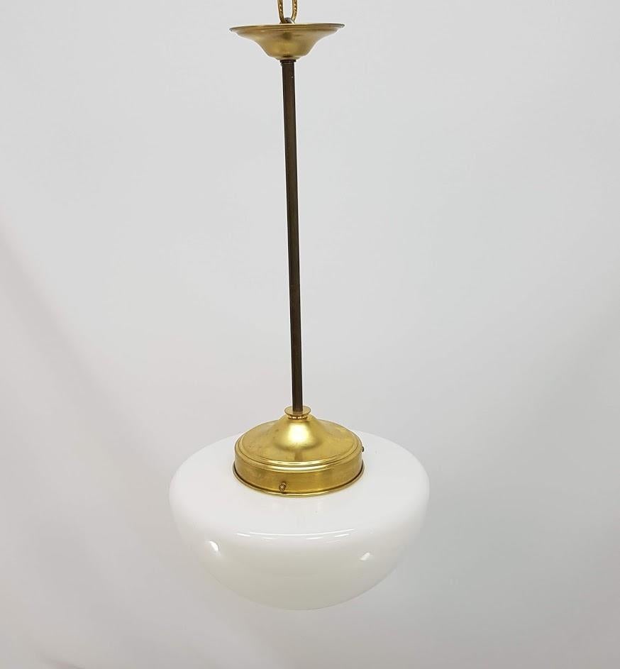 Simple and elegant brass pendant lamp natural metal finish, with tulip opal triple layer of flattened glass that reminds us of a mushroom hat. The length of the brass shank can be adapted and modified in length from 10 to 20 centimeters. It is