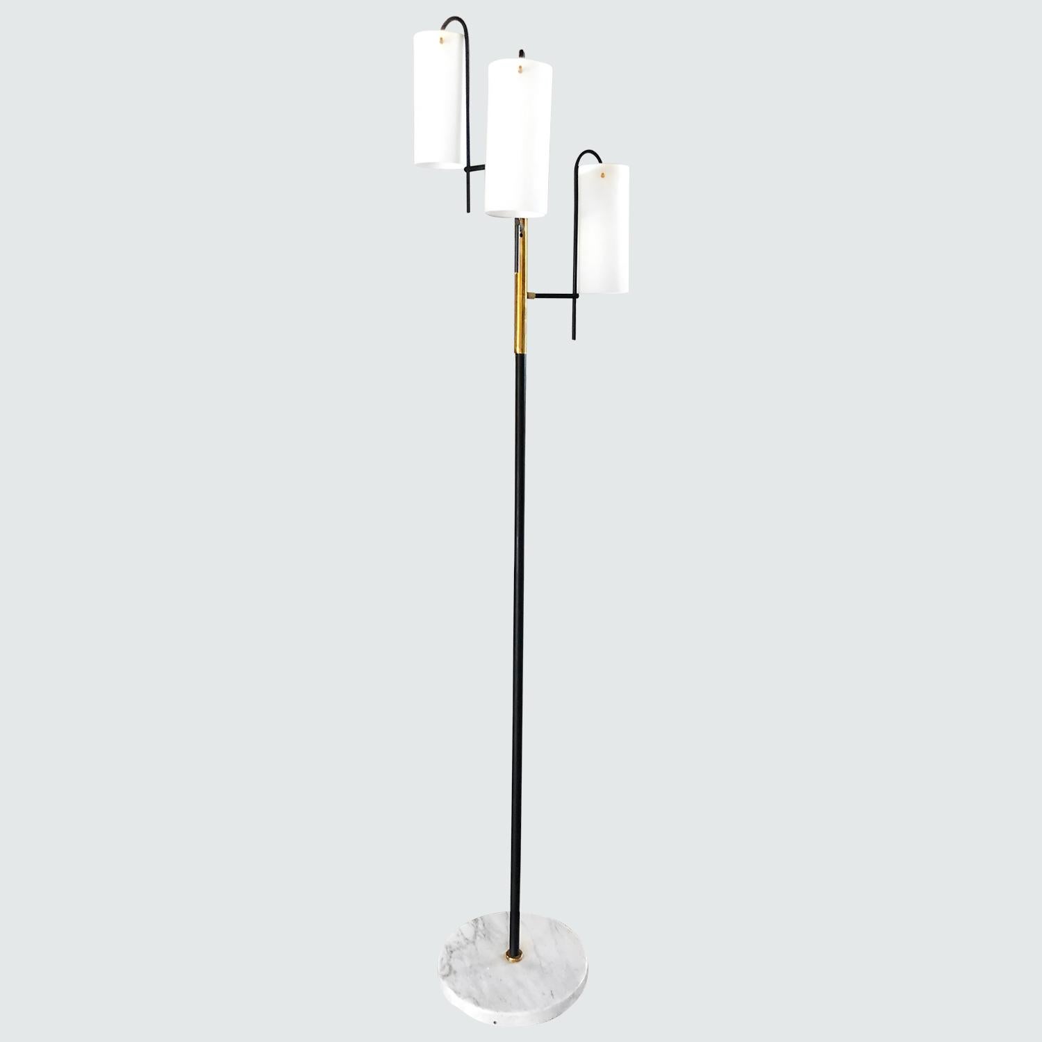 A vintage Mid-Century Modern Italian floor lamp made of a metal frame and brass, having three slightly curved arms with frosted, cylindrical opal glass shade which creates an astonishing light display. Produced by Stilnovo, each shade is featuring a
