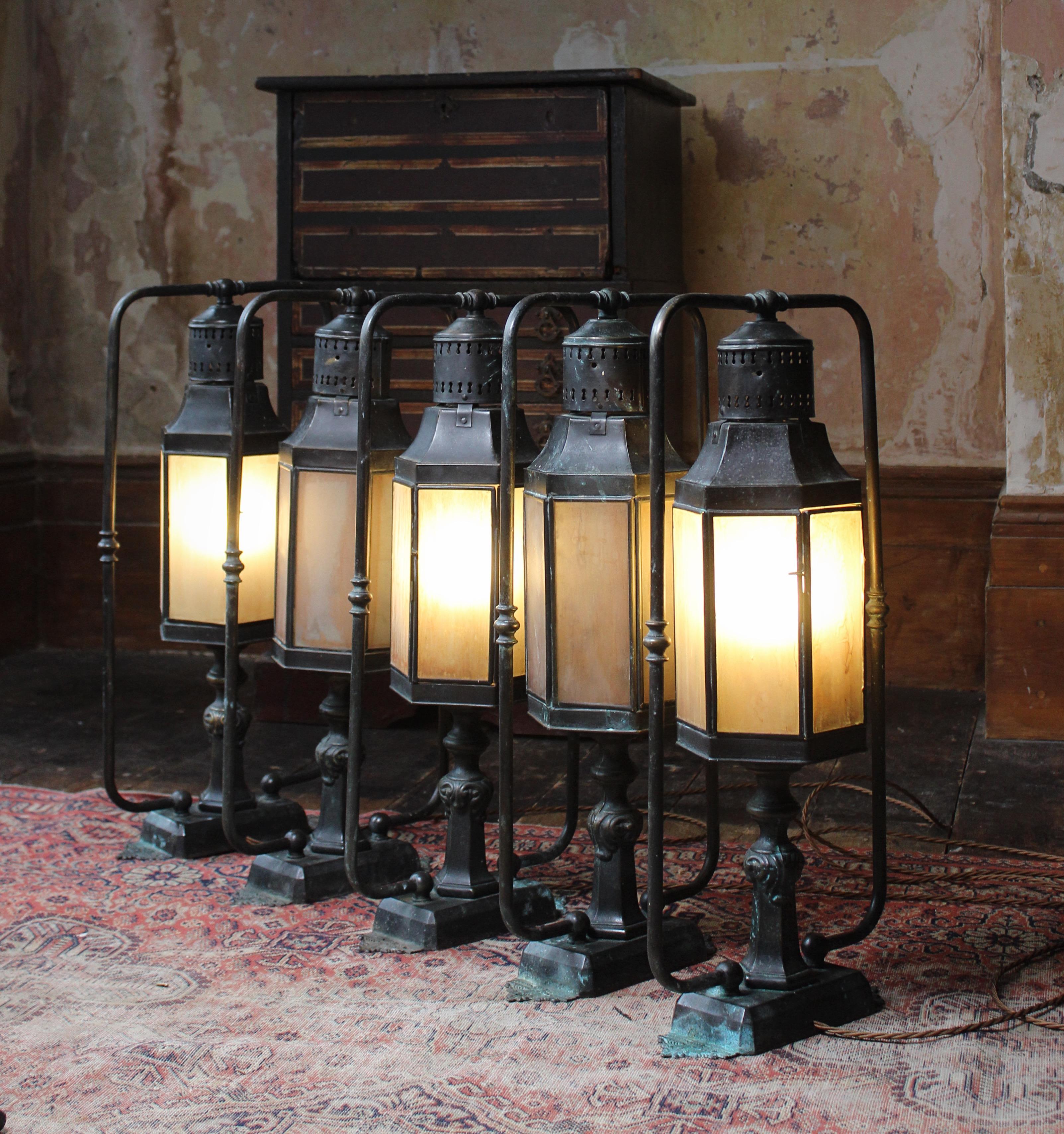 A good run of five ground/wall/pillar lanterns. Pressed and tubular brass with all their original marbled glass. 

Second quarter of the 20th century in age, English is origins. 

These would also make for great interior bed side, library