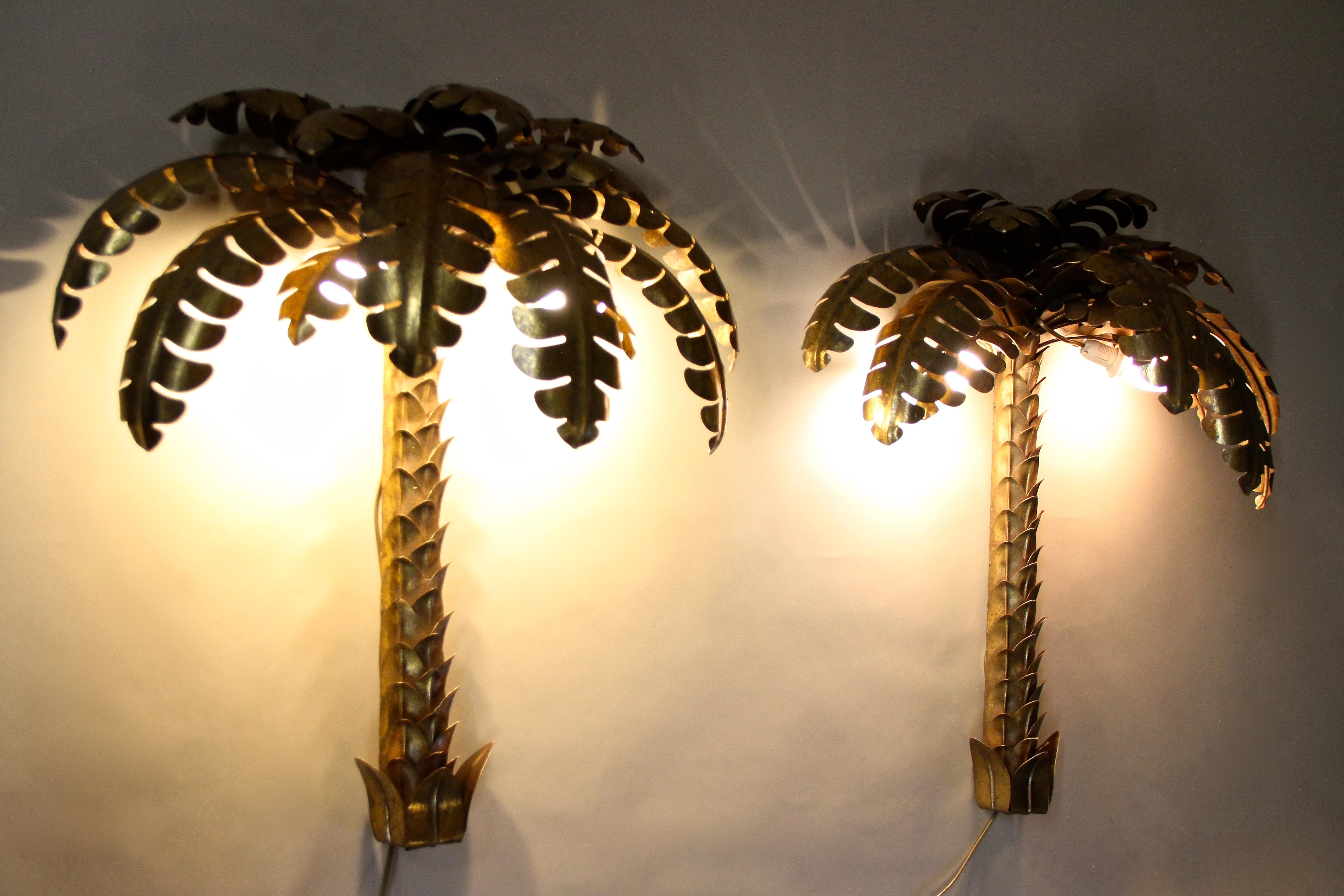 Absolute extraordinary pair of brass palm tree wall lights attributed to Maison Jansen in France around 1970. These rare, large wall lights were elaborately made out of fine brass and show a beautiful gilt/ patinated surface. The fantastic shaped