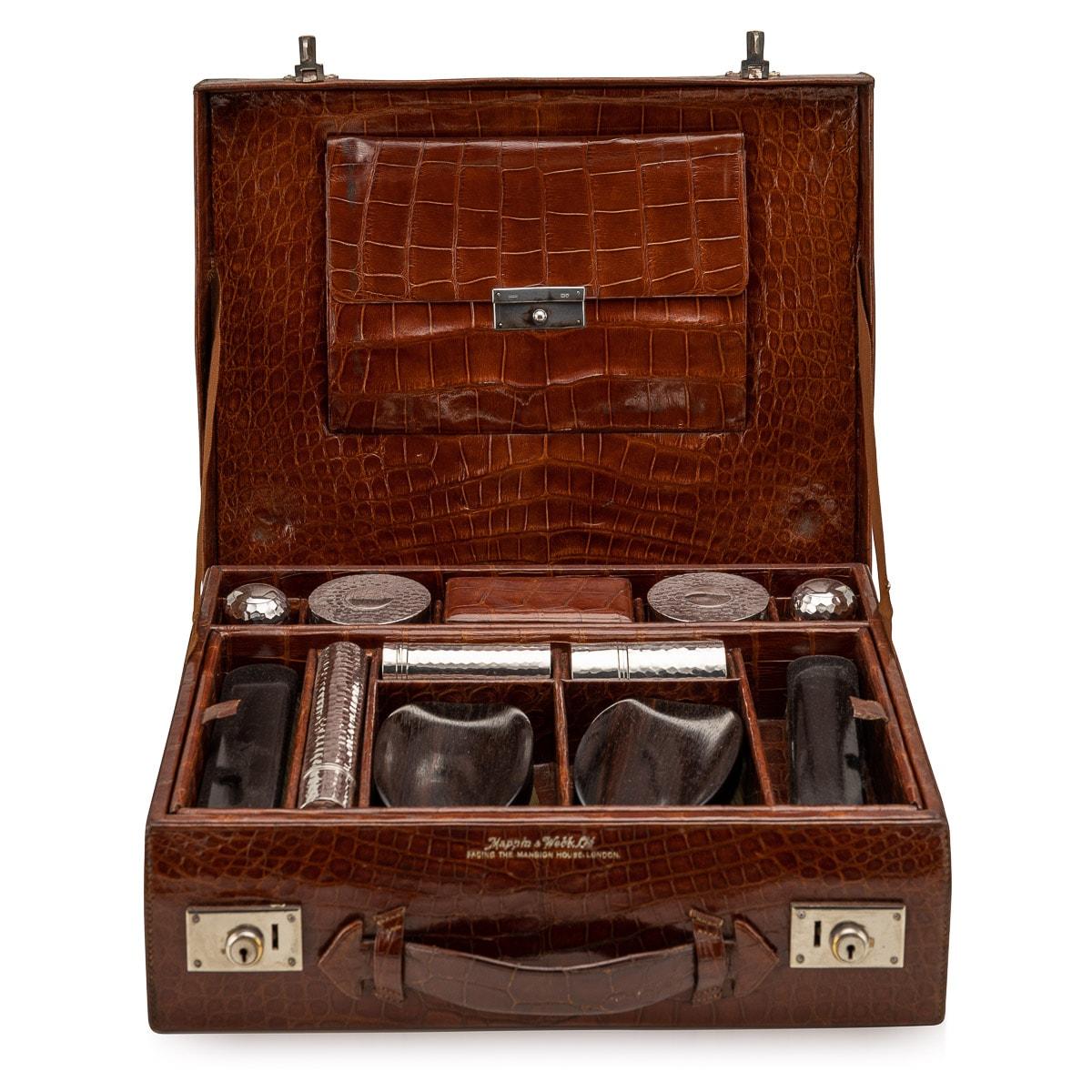 Antique early-20th Century British made crocodile overnight travel vanity case, with original cotton lining and small document holder on the inside. This tan crocodile vanity case has original bottles and jars in cut glass with silver tops, wooden