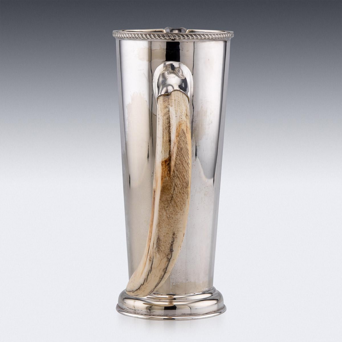 20th century British made silver plated and mounted with a boar tusk, mixing cocktail jug with a mixing spoon. The tapered body mounted with a cast gadrooned boarder and standing on a domed foot. Hallmarked RHV & CO, Made in England, circa