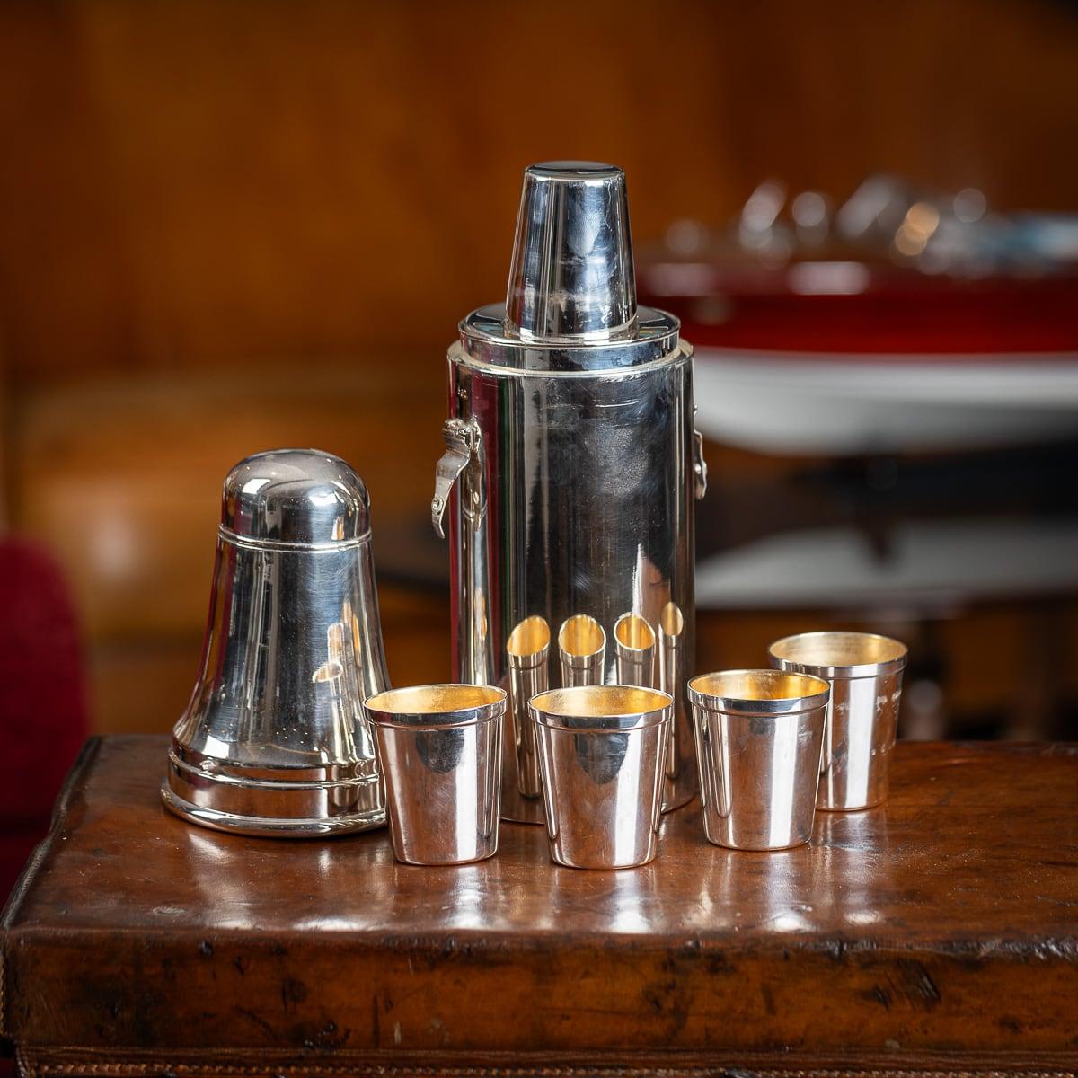 Shaker à cocktail en métal argenté britannique du 20e siècle, de grandes proportions, le corps agissant comme un Shaker, avec quatre gobelets gradués dorés, à l'intérieur contenant trois bouteilles de la distillerie James Burrough, aujourd'hui plus