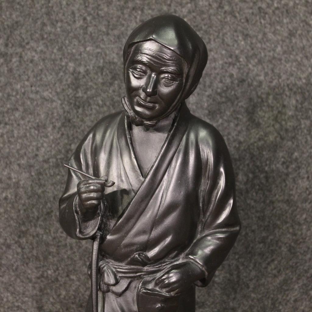 sculpture japonaise du 20e siècle. Bronze ciselé représentant un fumeur de pipe, un paysan oriental avec une houe, de belle qualité. Sculpture de petite taille, pour les antiquaires et les collectionneurs, idéale pour une collection de bronzes et de