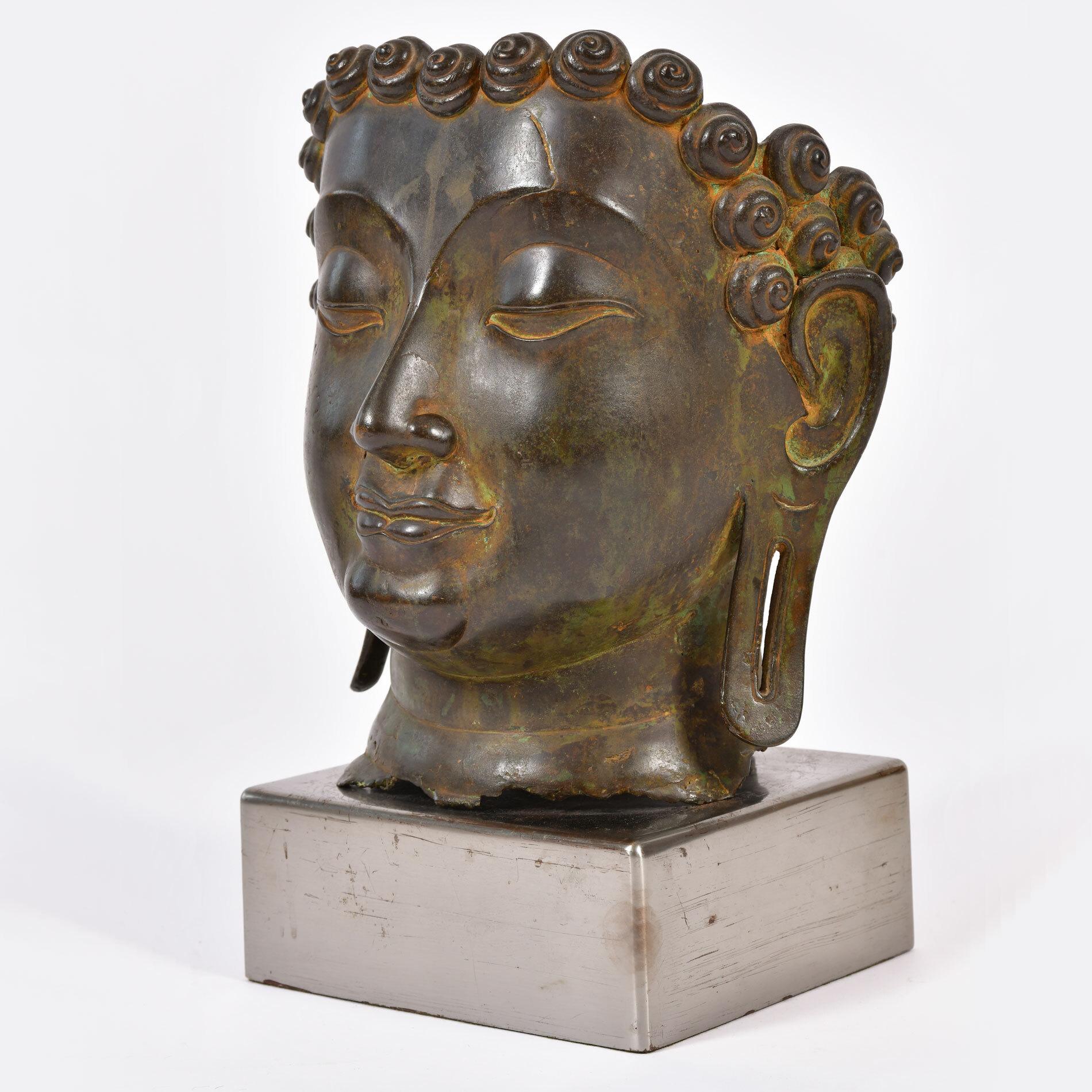 Buddha head sculpted in bronze. Sits on square chrome stand.