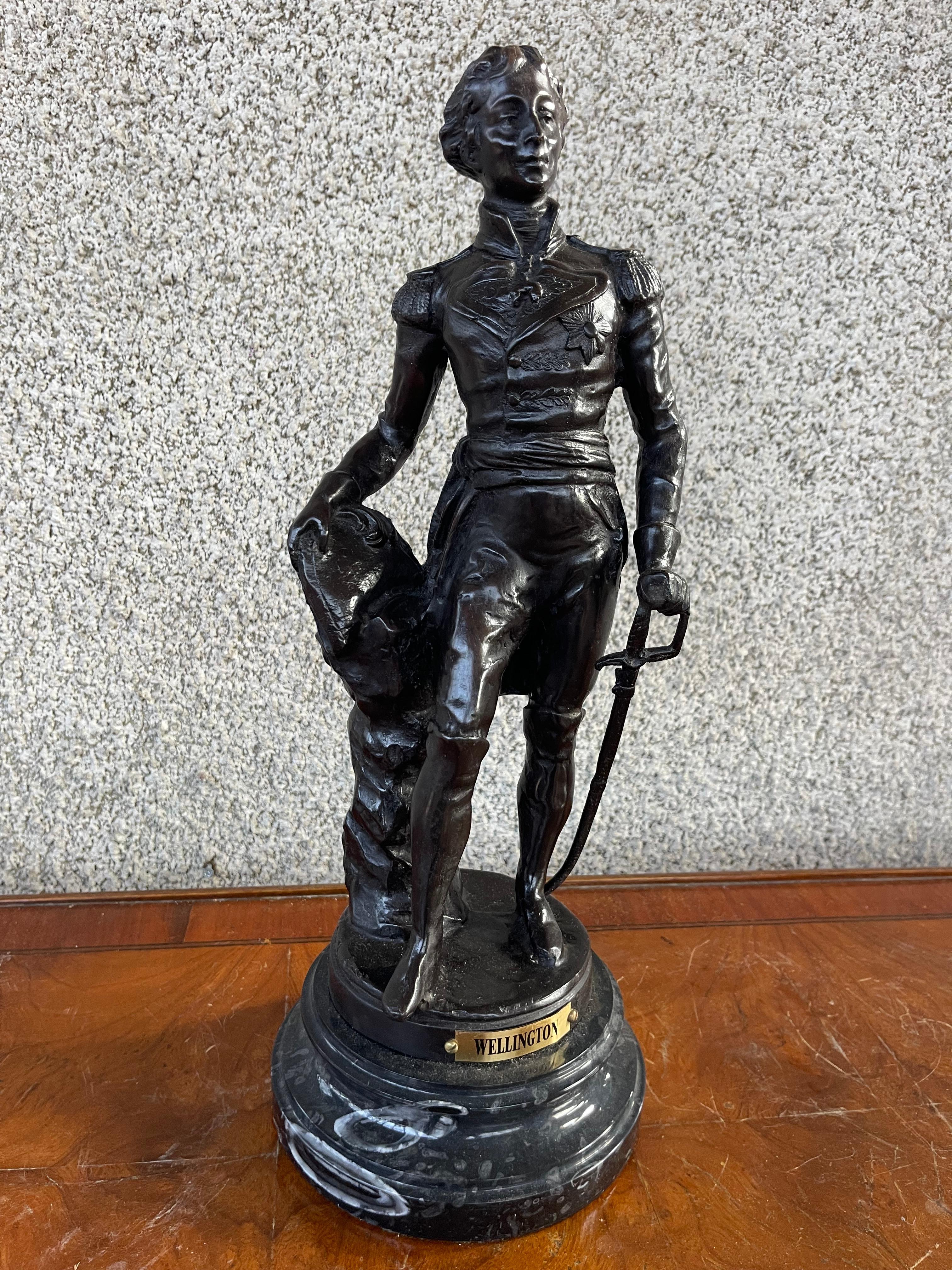 This 20th-century bronze figure of Wellington in military attire depicts Arthur Wellesley, 1st Duke of Wellington, a prominent military and political figure in British history. 

Arthur Wellesley, 1st Duke of Wellington (1769-1852) is best known for