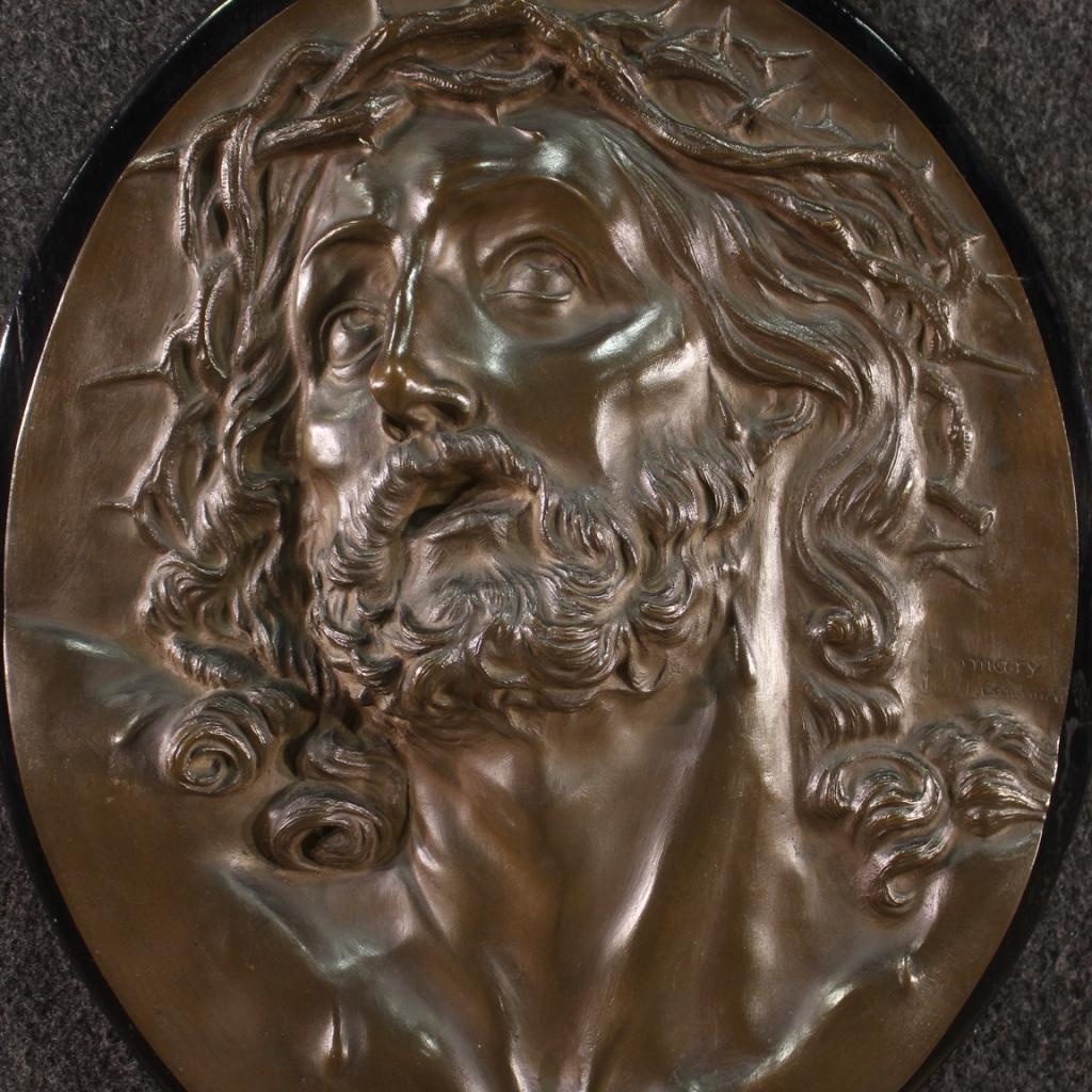 Italian bas-relief from the first half of the 20th century. Exceptional quality bronze work fixed on a lacquered wooden panel. Sculpture depicting the face of Christ finely chiseled in the smallest details, with an oval shape. Work that has a