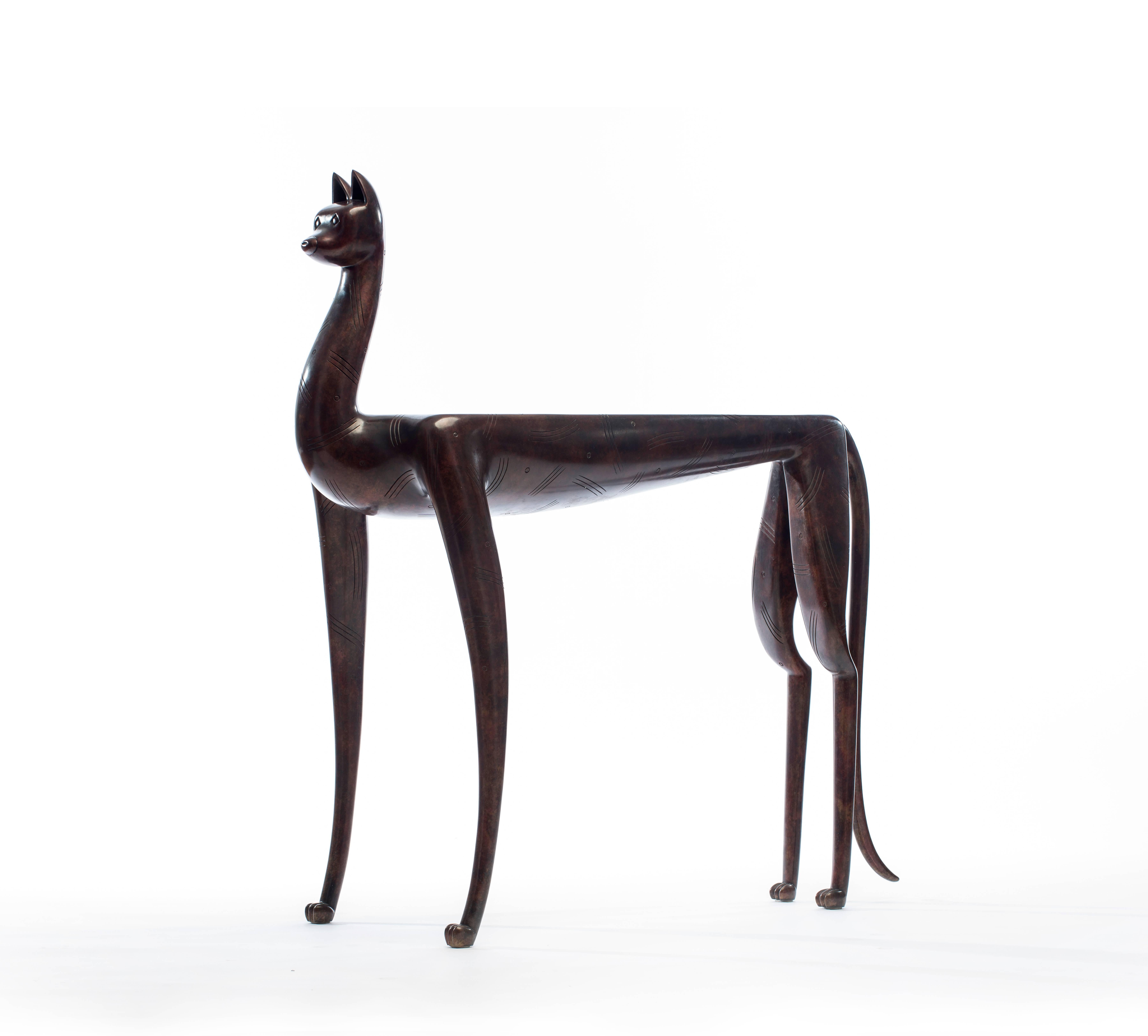 Lynx table by Judy Kensley McKie was created using cast bronze with applied patina and glass. It is stamped 