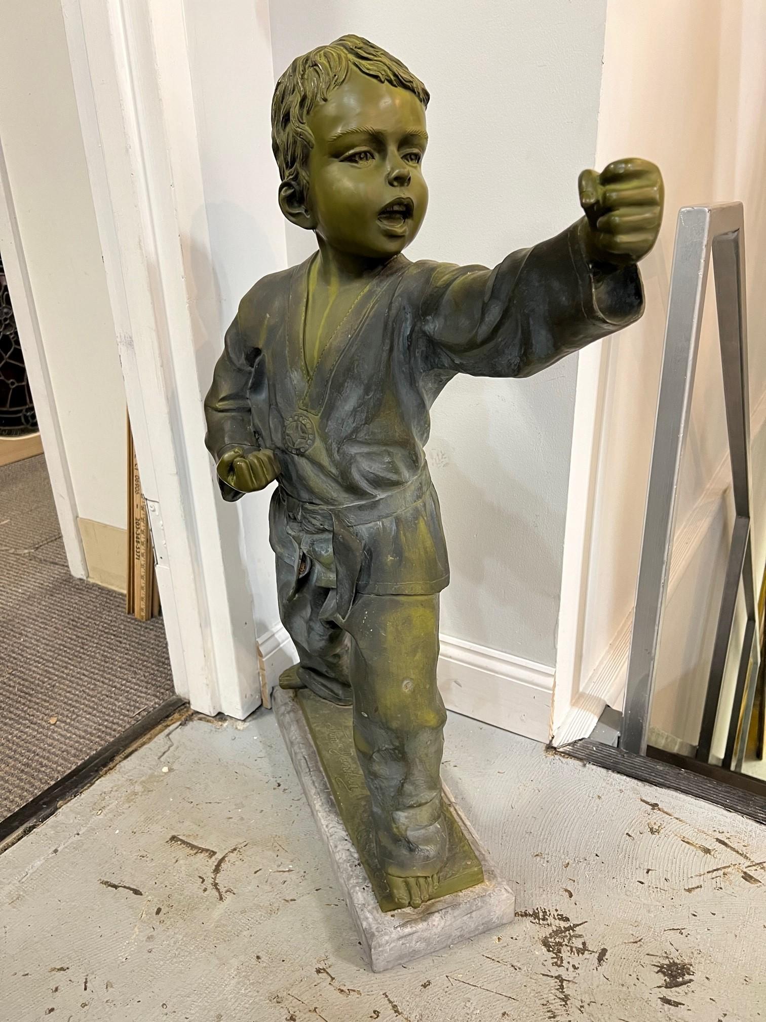 Late 20th century bronze martial arts boy or Karate Kid statue on a marble base. Its been outside for many years and is weathered but in good condition, only a small chip on the base. The bronze is signed Jim Davidson which I believe is a fictional
