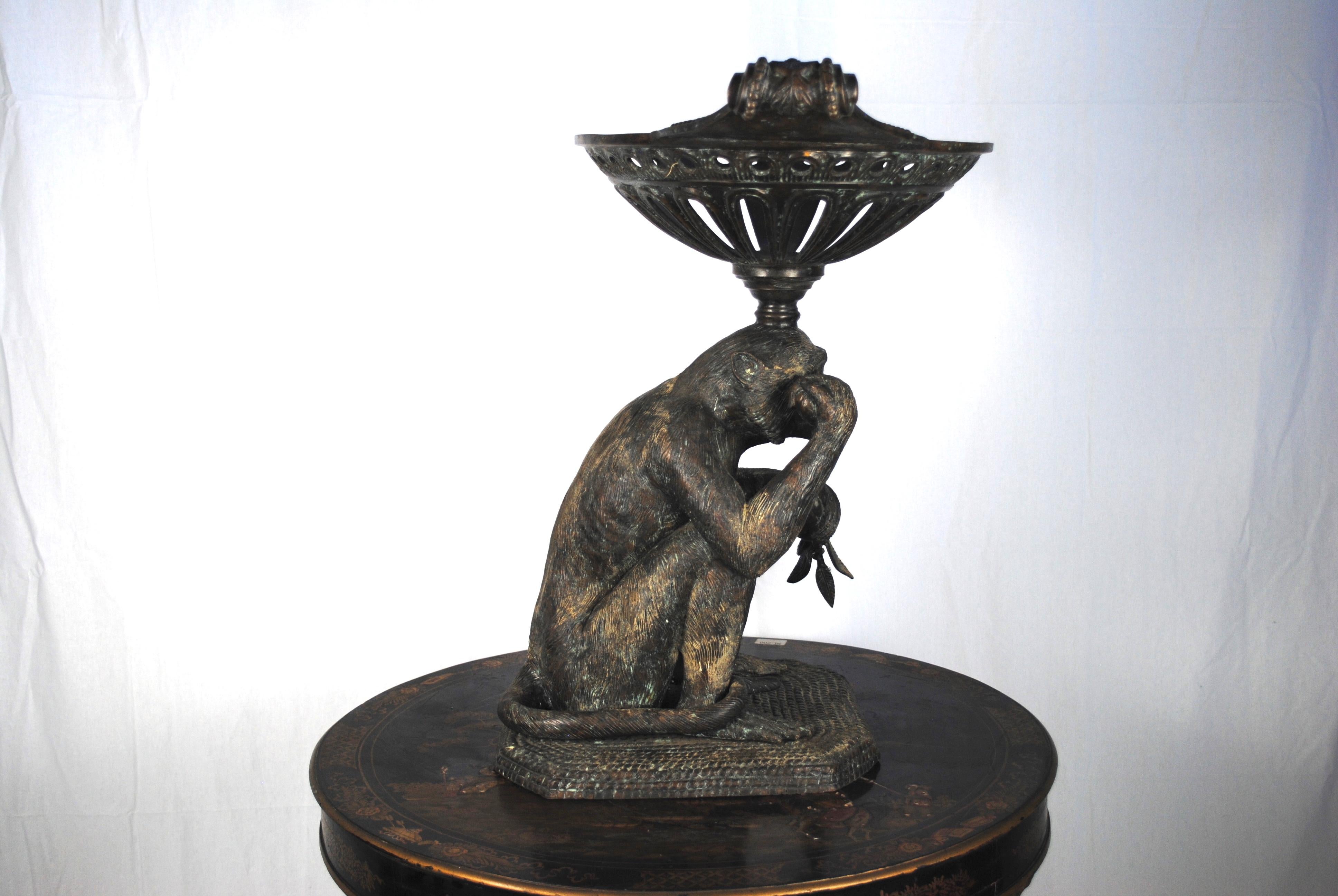 A 20th century bronze monkey with a bronze basket balanced on its head and holding a sprig of foliage in its hand.
A stunning centre piece for a reception or dining table. Could also be used as a garden ornament.
 