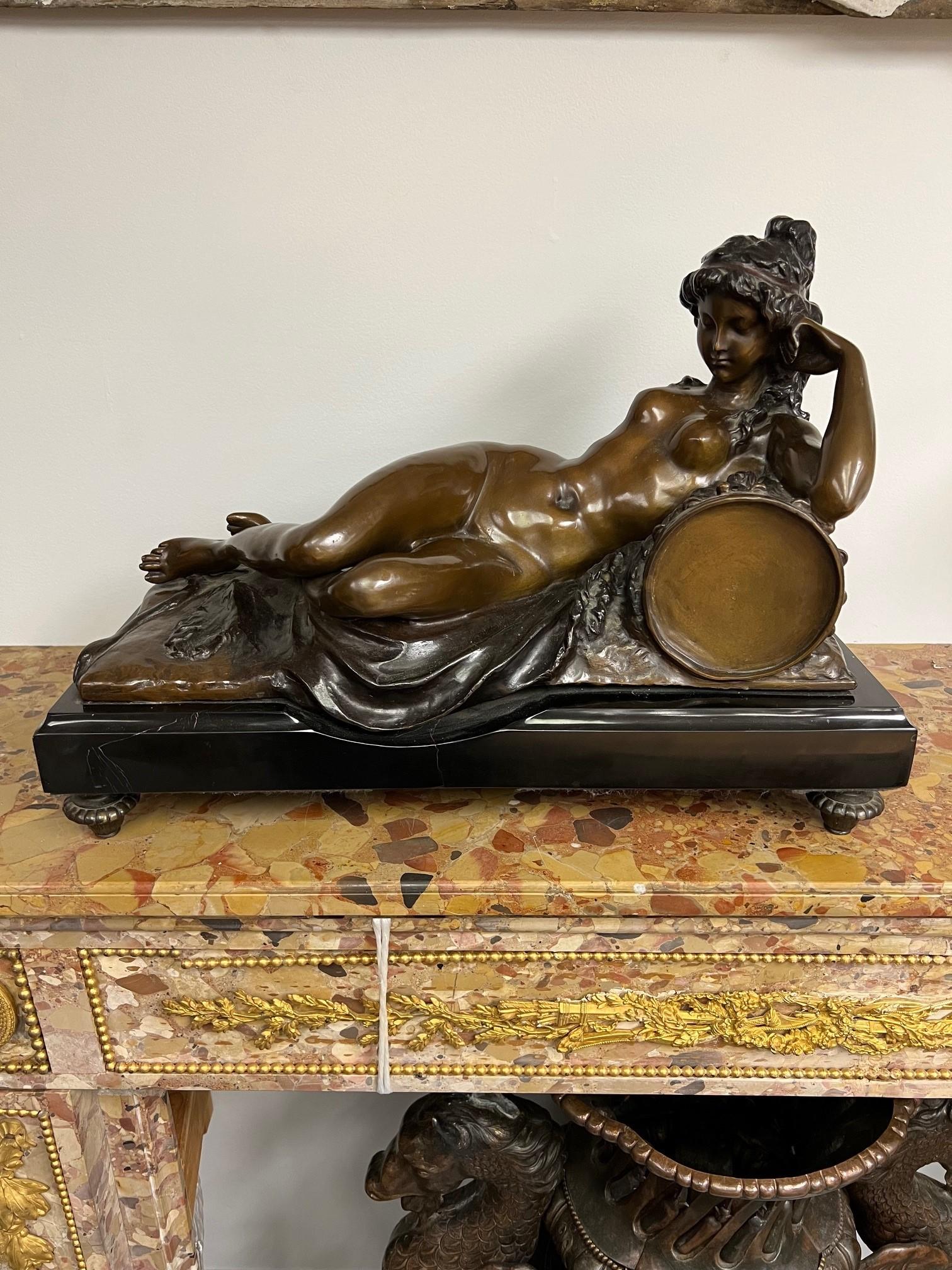 Figura in bronzo del XX secolo raffigurante una Baccante nuda e sdraiata
la ragazza nuda sdraiata su una pelle di leone, con un tamburello accanto a lei, patinatura marrone medio, firmata Shabtai, sollevata su un basamento di ardesia nera sopra