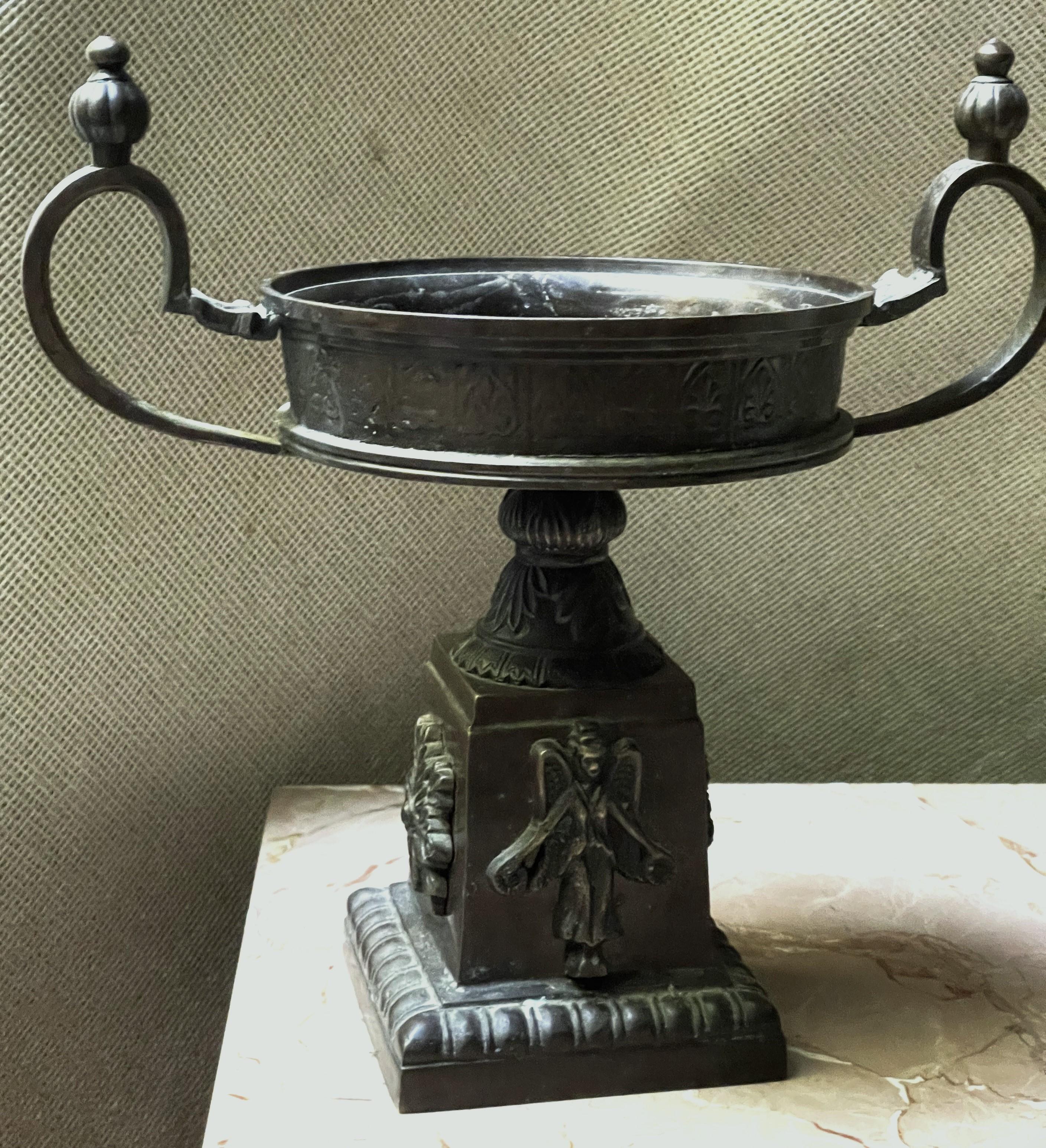 Here is a heavy, classic style pedestal base wide, flat urn top bronze tazza with lovely art nouveau impressed decoration all over. The raised, wonderfully detailed angels and snowflakes are applied to alternating sides of the base and the wide