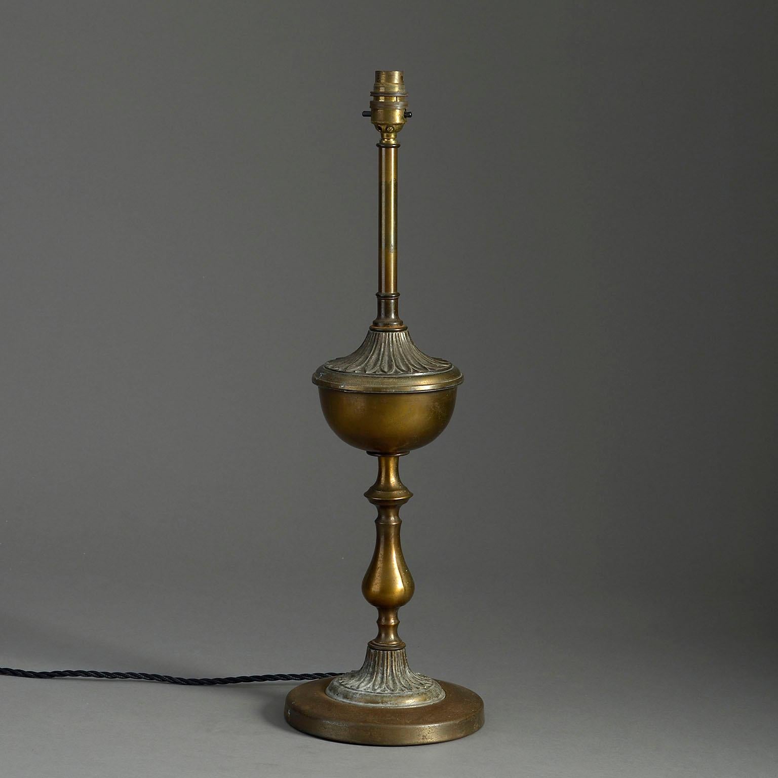 An early 20th century bronze patinated column lamp in the Neo-classical taste, the fluted vase upon a baluster stem and set upon a circular socle.

Height listed is to light bulb fitting.

Wired for UK safety standards. This lamp can be re-wired