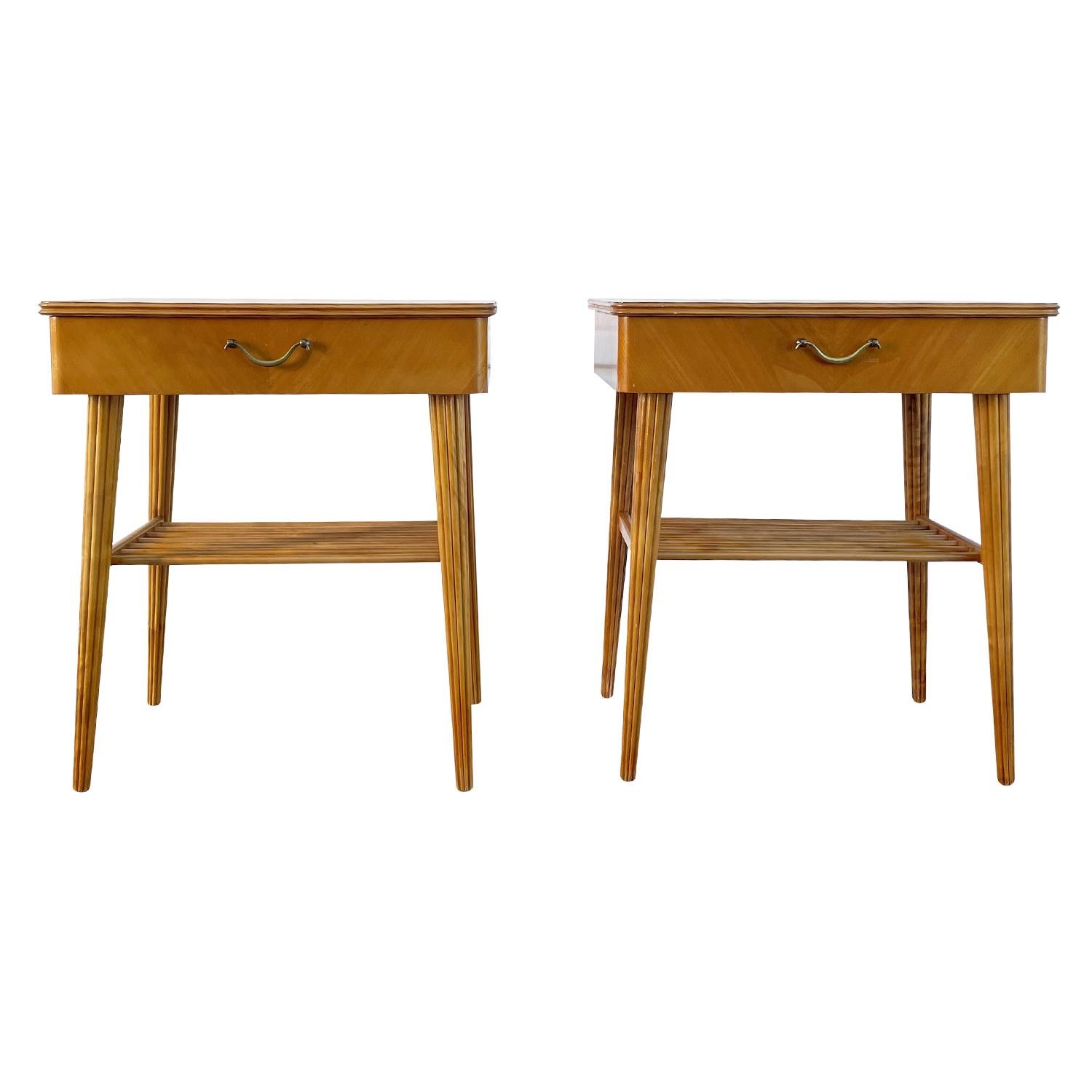 A light-brown, vintage Mid-Century Modern Danish pair of nightstands made of hand crafted Birchwood, in good condition. Each of the Scandinavian bedside tables are composed with one drawer, brass handle and a spindled shelf, supported by four