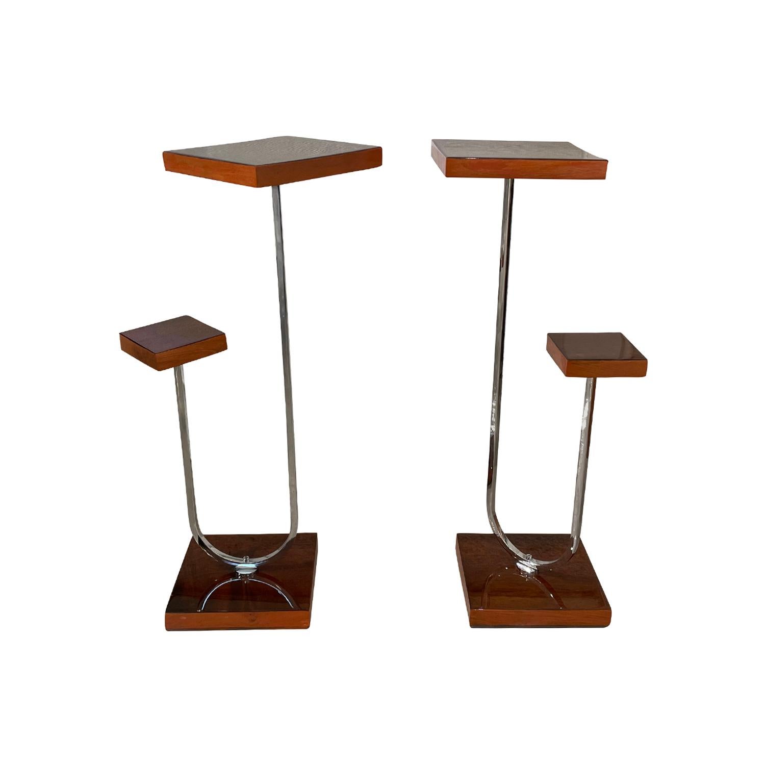 A small, vintage Art Deco Italian pair of pedestals, side tables made of hand crafted polished Mahogany, in good condition. Each of the tabletop square is supported by a curved chrome arm, supported by a wooden base. Wear consistent with age and