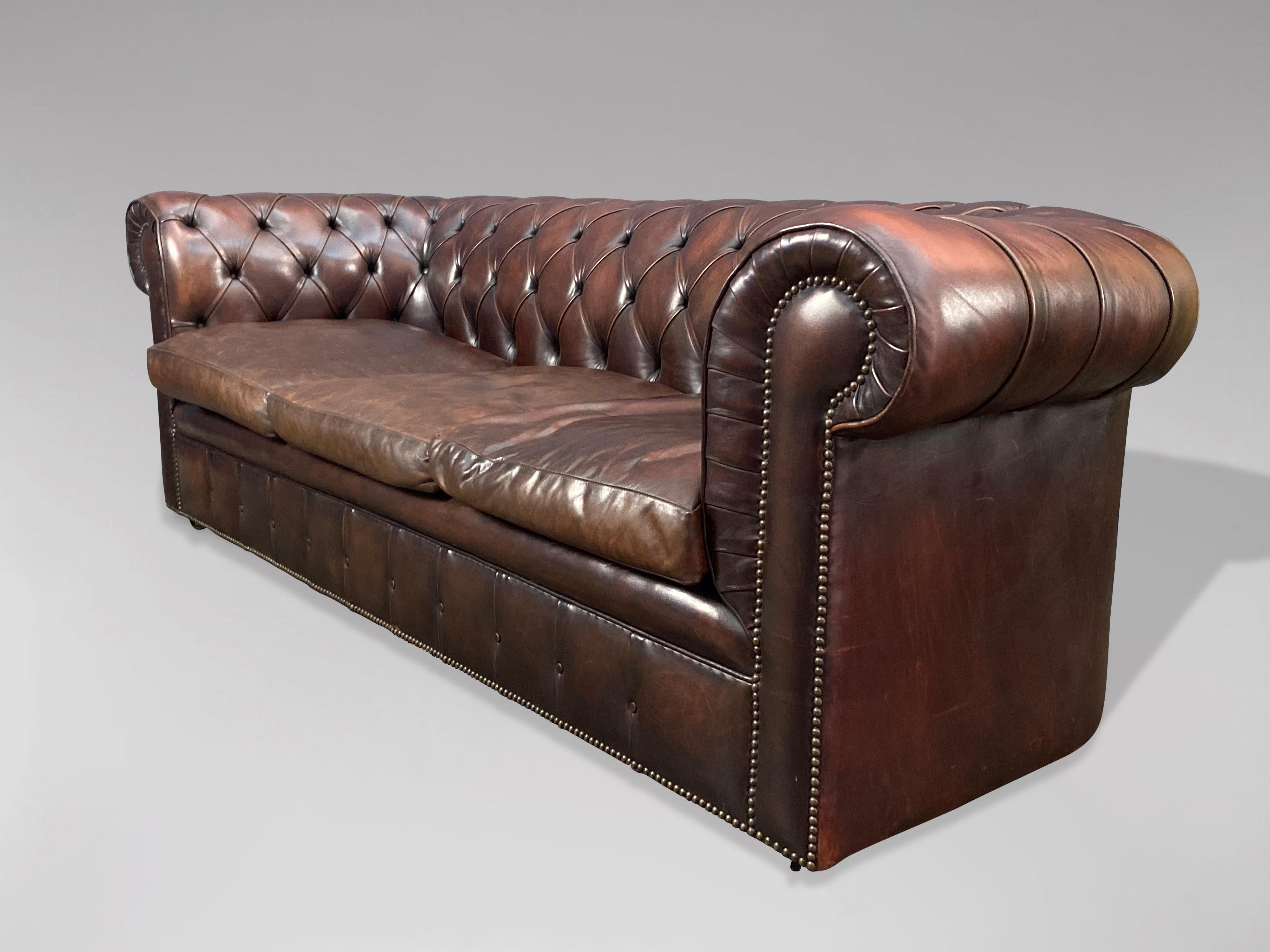 A superb quality early 20th century large three seater brown leather chesterfield with three loose feathered cushions, raised on castors. A fine example of a good quality with a good patina comfortable chesterfield. With the original quality brown