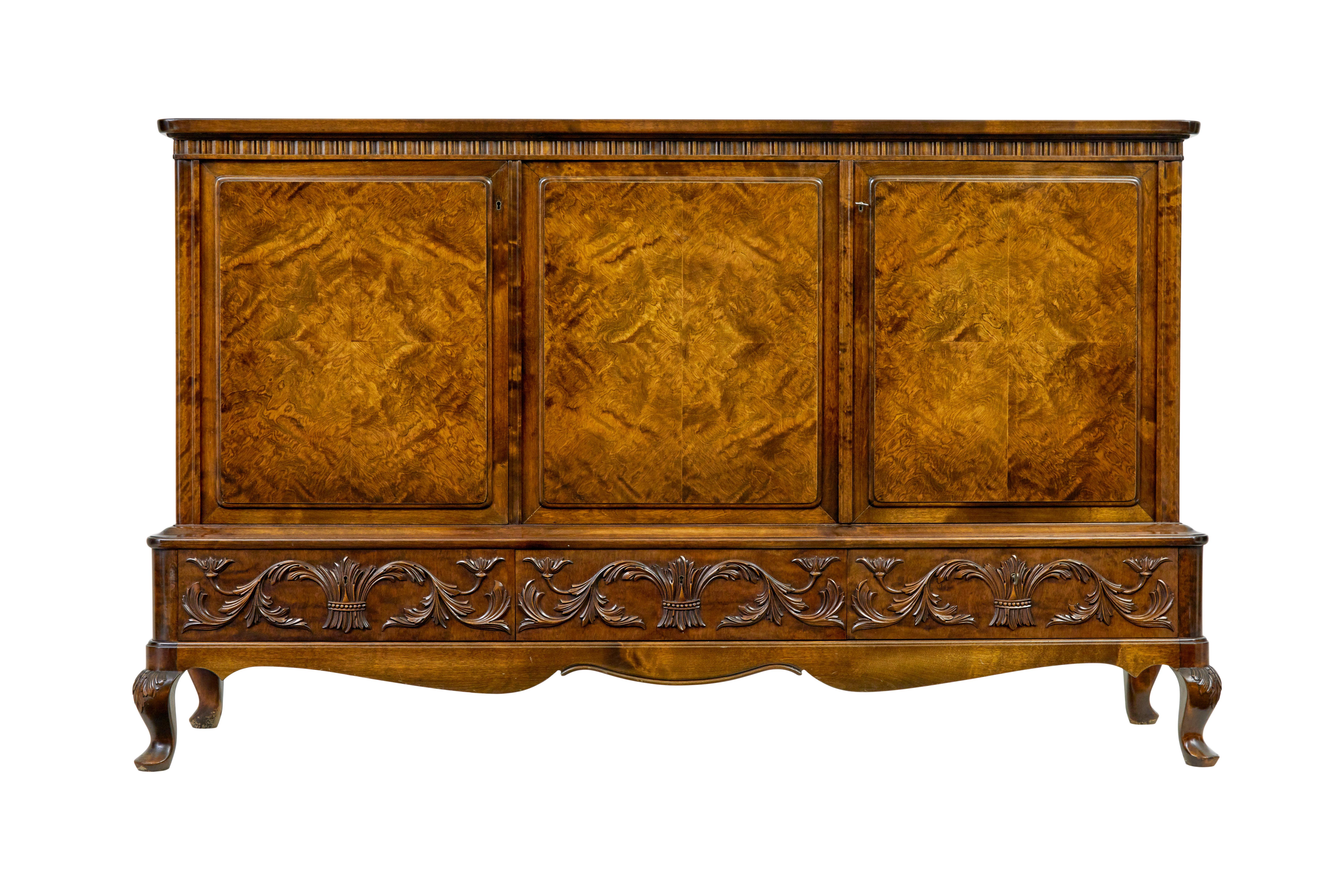 Stunning Karelian birch sideboard made by SMF Bodafors.

Beautiful colour and burr birch veneers used on this piece. 3 doors to the front providing a double door and a single door cupboard, each with quarter matched veneers.  Interior with 2