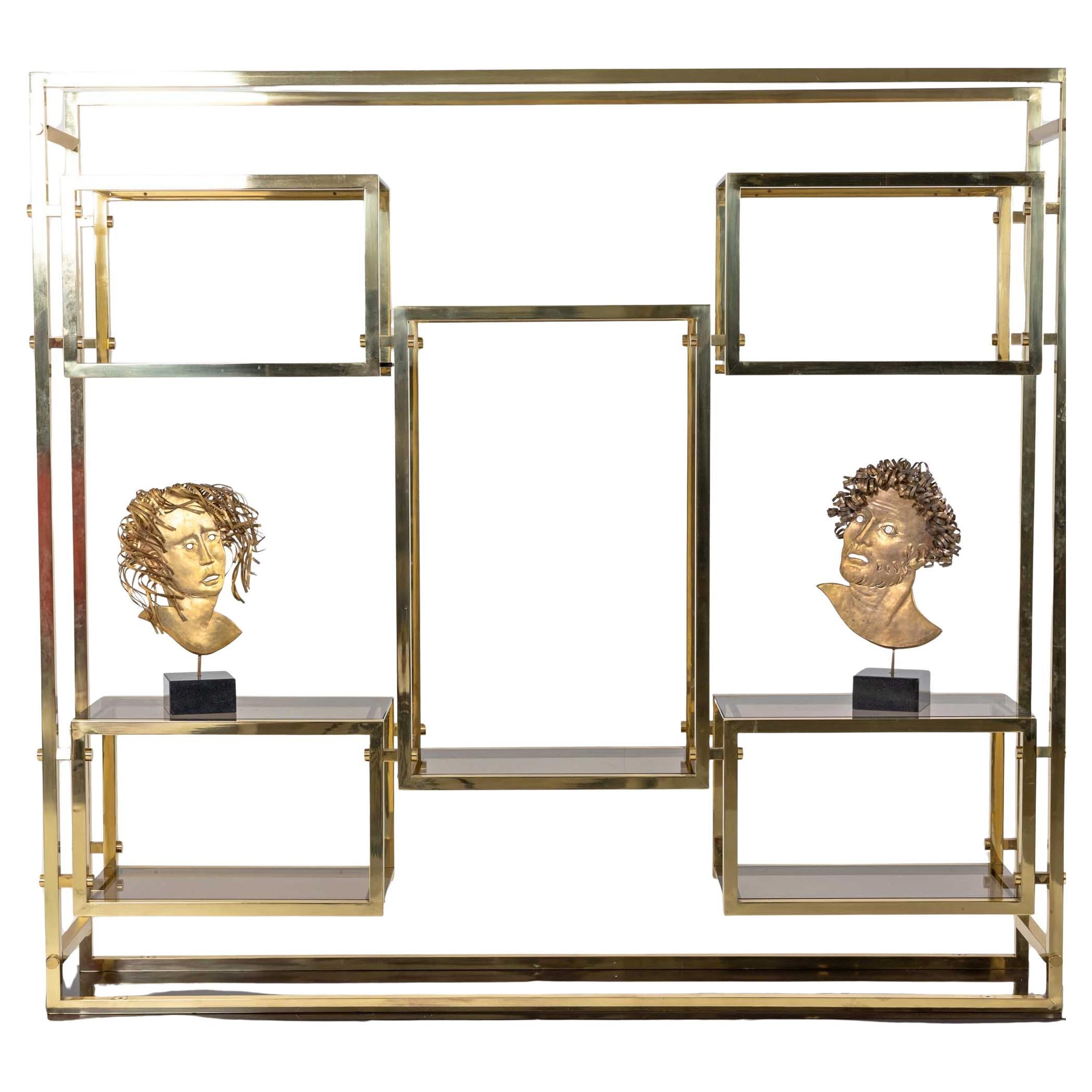 Büsten von Romeo und Julia aus geprägtem und vergoldetem Kupfer. Romeo wird in Form eines bärtigen Mannes mit lockigem Haar und Julia mit zurückgeschlagenem Haar und ernstem Blick dargestellt. Die Masken sind auf quadratischen Granitsockeln montiert