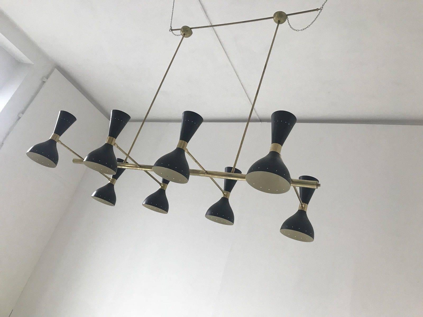 Beautiful and rare large rectangular chandelier in the style Stilnovo Italian designer eight-arm with 16-light.
Solid brass structure, eight arms with eight articulated lampshades in black lacquered metal with ivory interior.
The lampshades are