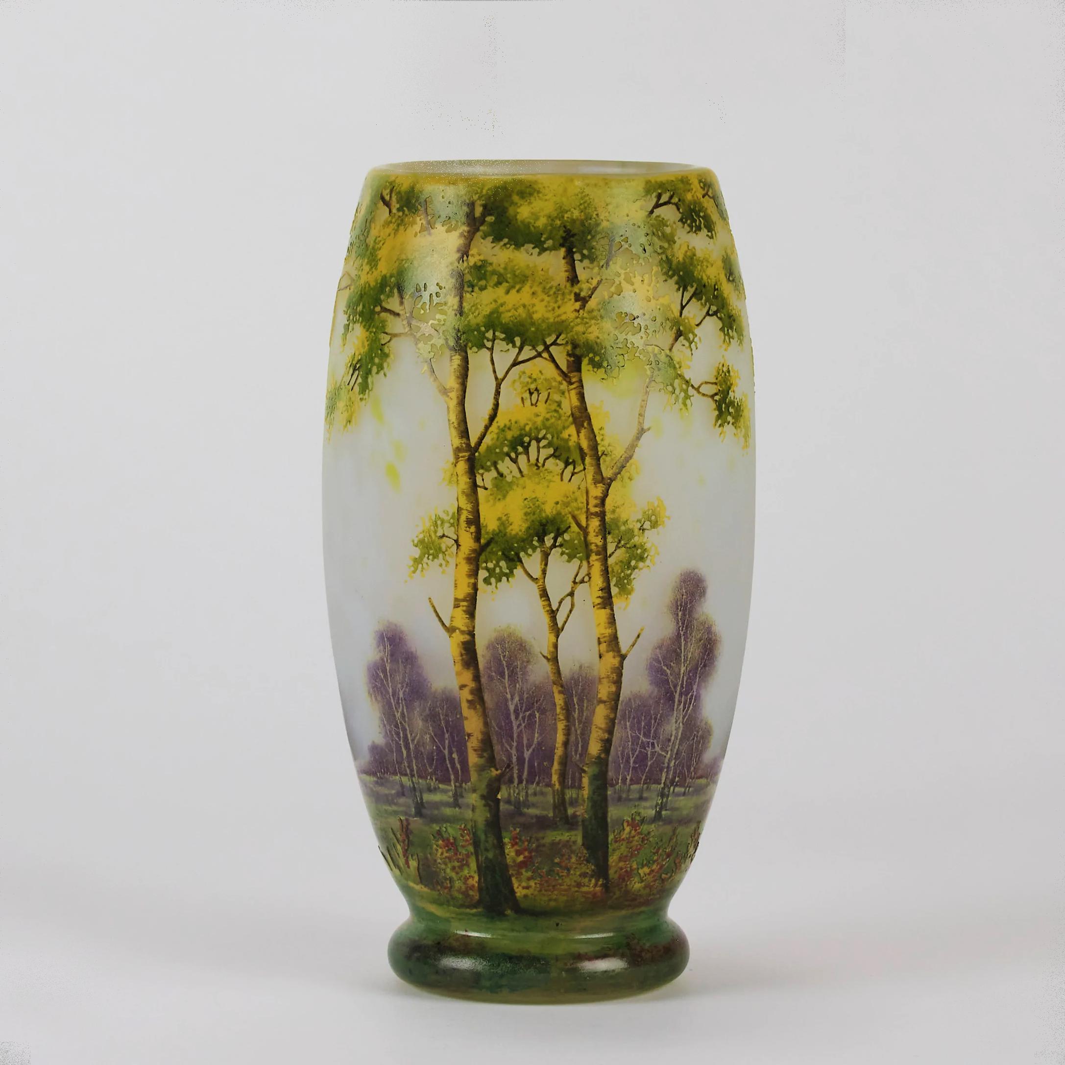 Un étonnant vase en verre camée Art Nouveau gravé et émaillé d'un paysage d'été riche et profond incorporant des arbres vibrants dans un paysage boisé, présentant d'excellentes couleurs et détails, signé Daum Nancy avec la Croix de