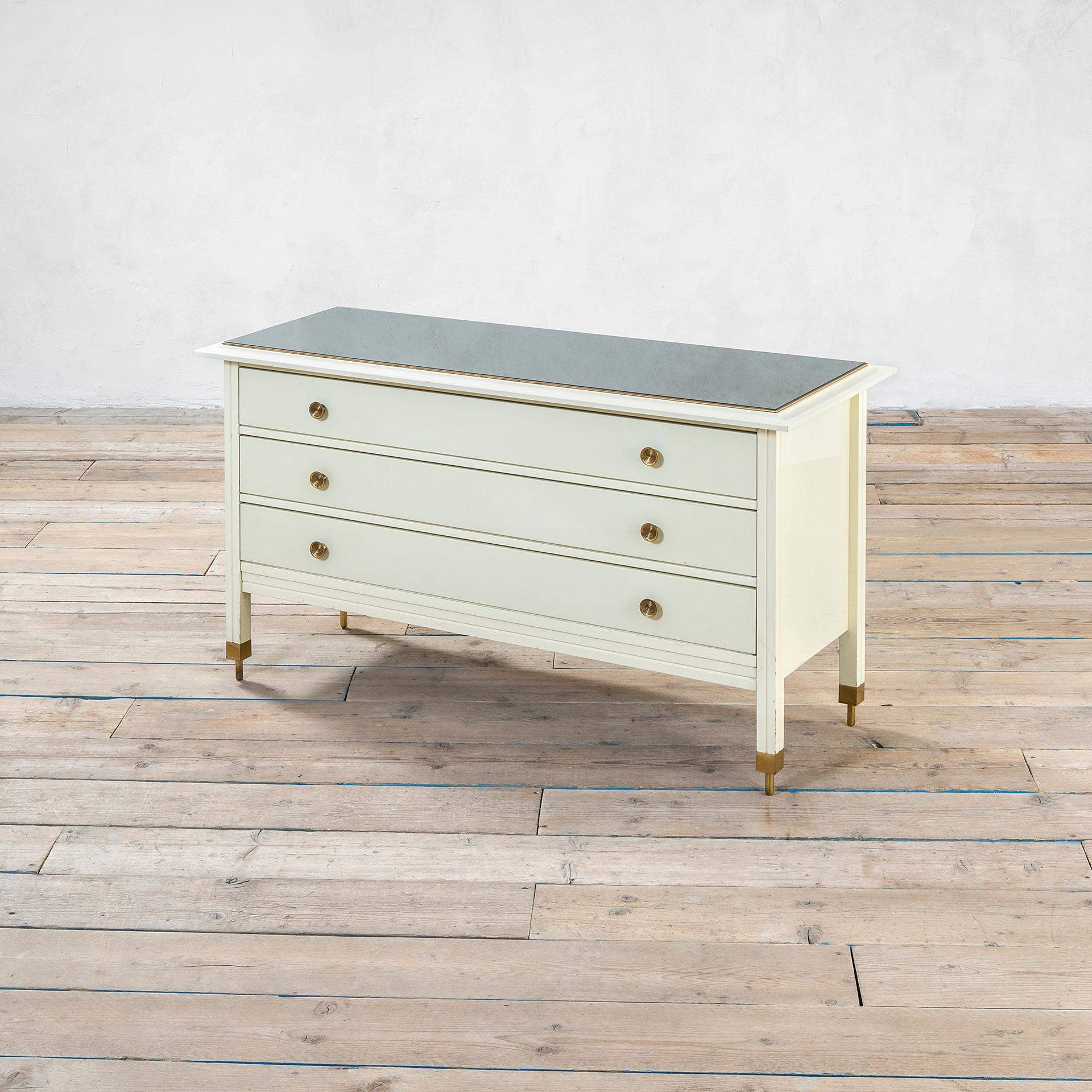 Chest of drawers (three drawers) designed by Carlo De Carli in '60s for Sormani Production. The structure is in white lacquered wood, the top is covered by a mirrored glass; the most peculiar detail is on the feet of this table, infact each foot is
