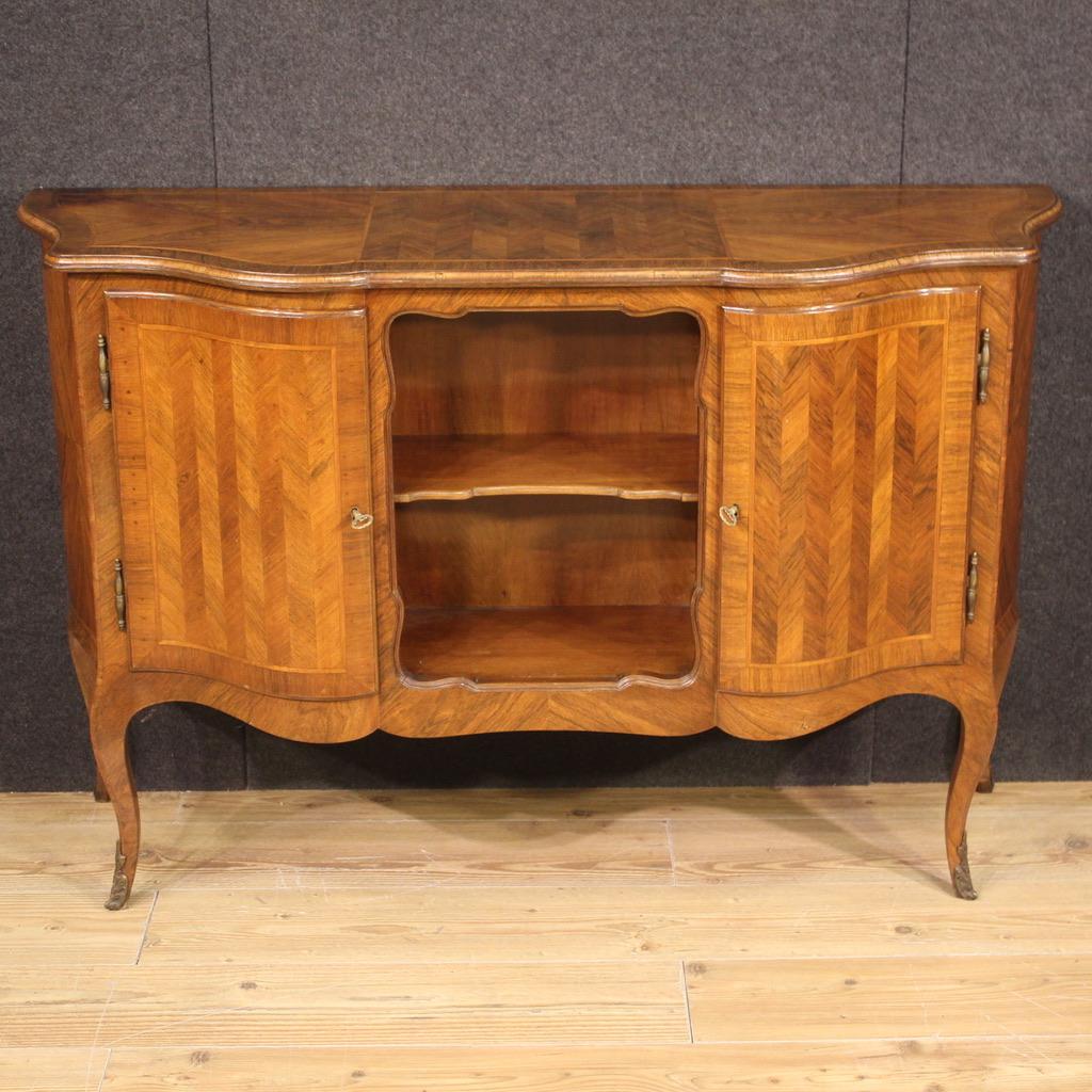 Buffet italien du milieu du 20e siècle. Meuble magnifiquement conçu, incurvé sur la face avant et les côtés, sculpté et plaqué en noyer et en bois fruitier. Buffet avec deux portes latérales, un compartiment central ouvert et un compartiment secret