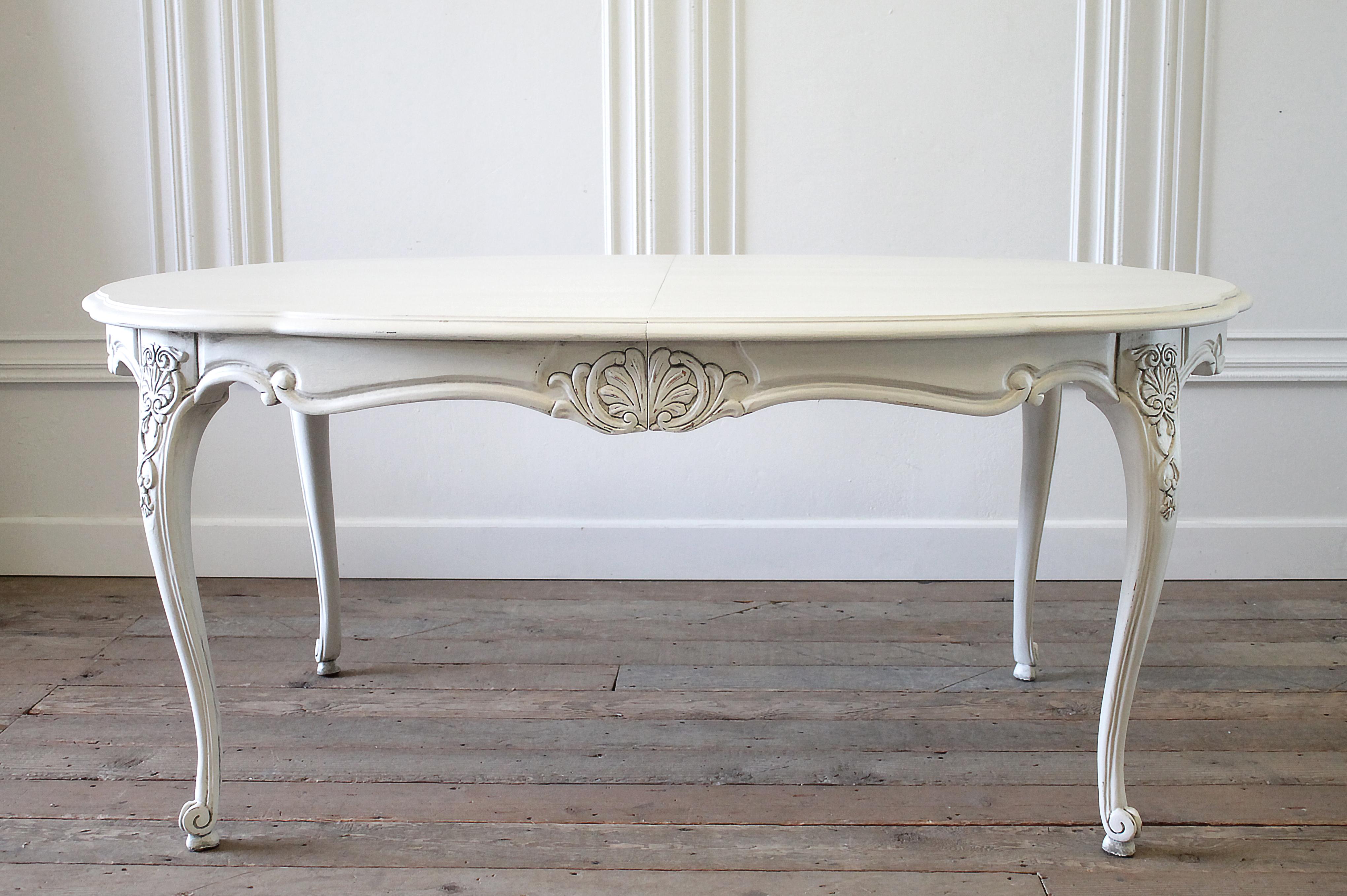 20th century carved Louis XV style dining table with leaves
This dining table comes with two large extensions leaves that have the same carving on the apron to give a complete finished look. Painted in a soft oyster white, with subtle distressed