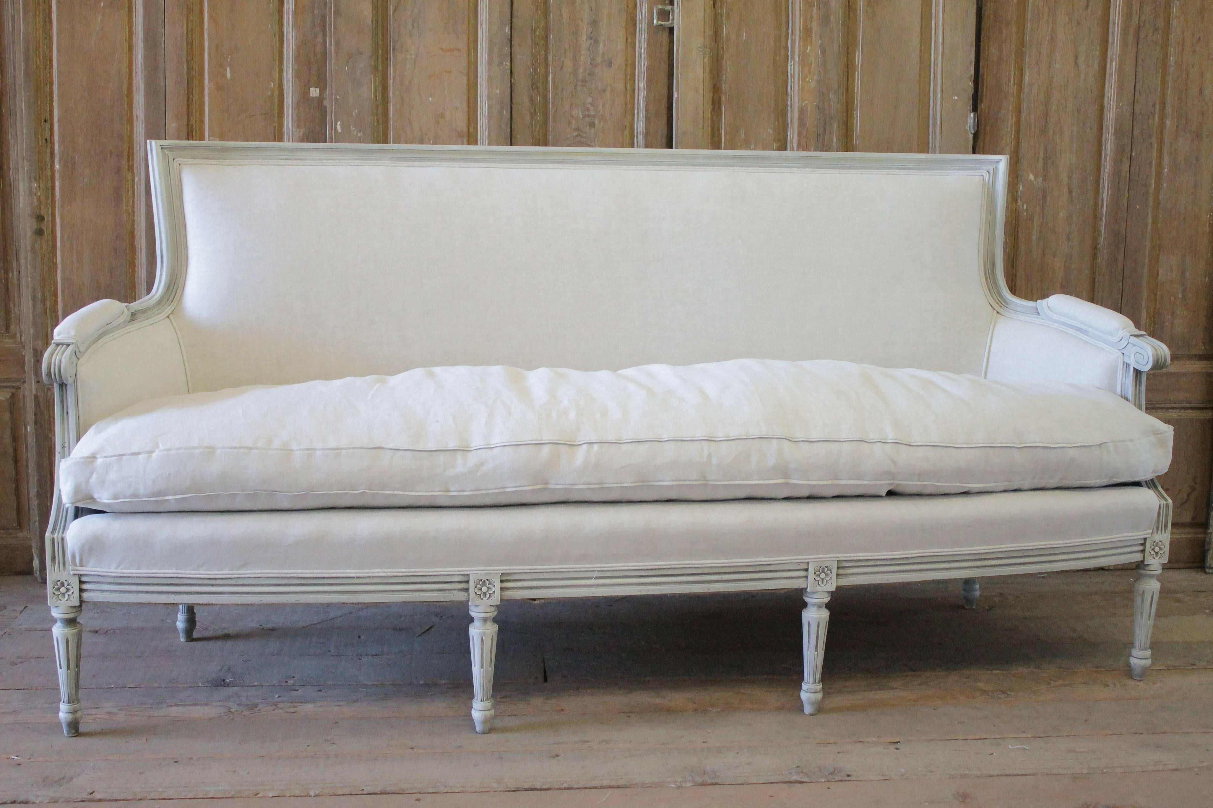 20th century carved Louis XVI style painted French sofa upholstered in linen
Painted in an oyster white with subtle distressed edges and hand glazed patina. Color come across as an off-white, with subtle greyish tone. Upholstered in a 100% pure