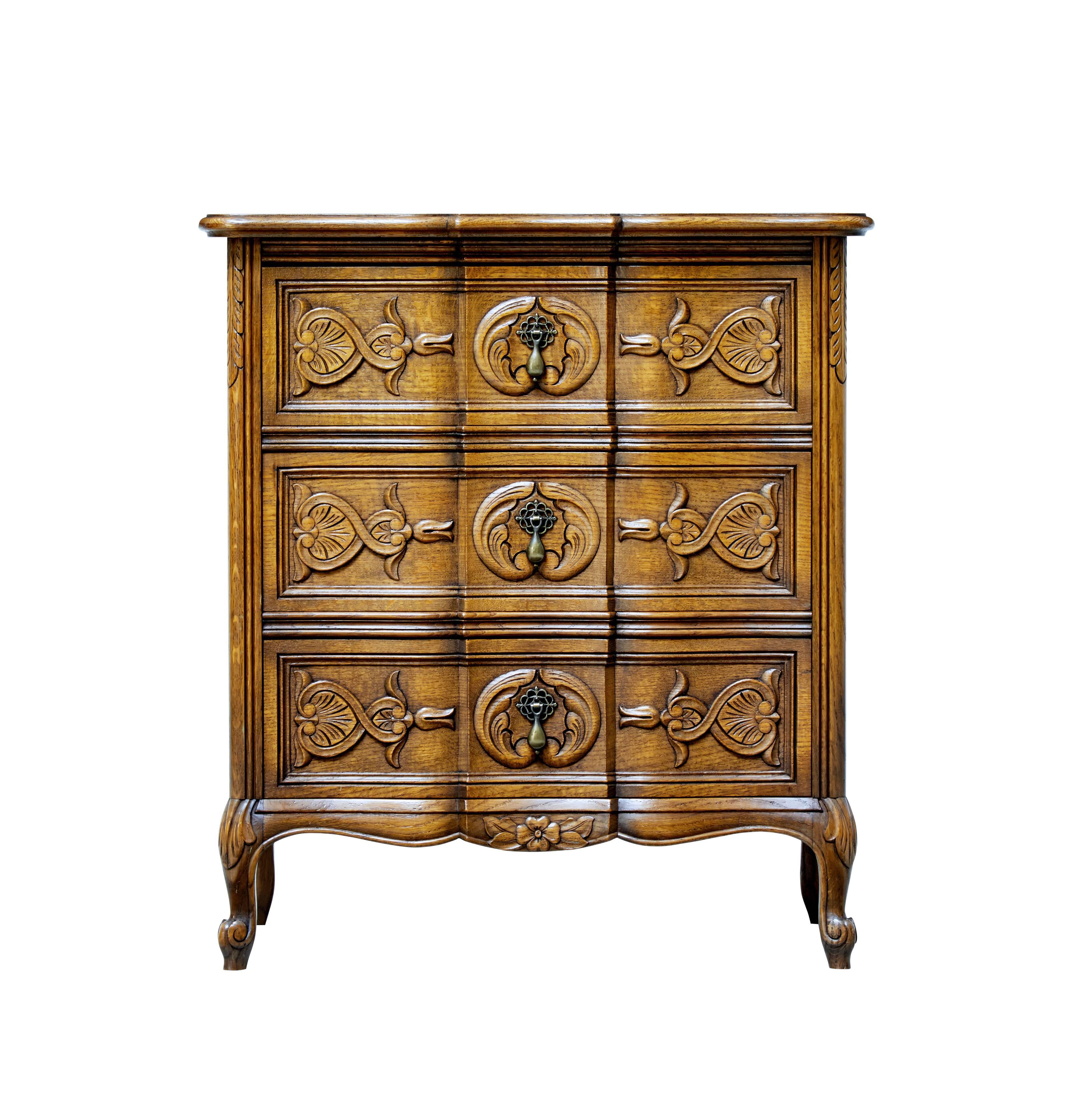 1950s Baroque style three-drawer commode.

Three-drawer chest of drawers of small proportions. Single brass drop handles to the front.

Carved drawer fronts, standing on four scrolling legs.