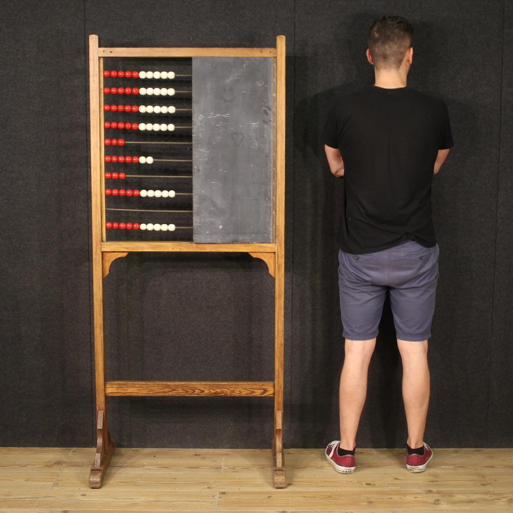 Dutch school abacus from the mid-20th century. Furniture of rustic character carved in fir wood, very pleasant. Abacus supported by two solid legs, complete with blackboard mounted as a door (see picture). Abacus complete with 10 iron elements with