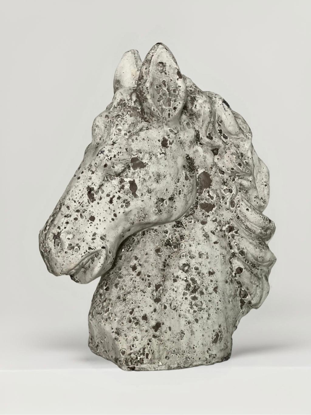 Vintage 20th century hollow cast cement horse head bust. It displays a flowing mane, calm expression with a slight turning of the head and beautiful, aged patina. A great decorative element for indoors or outdoors on a mantle, pedestal, console/desk