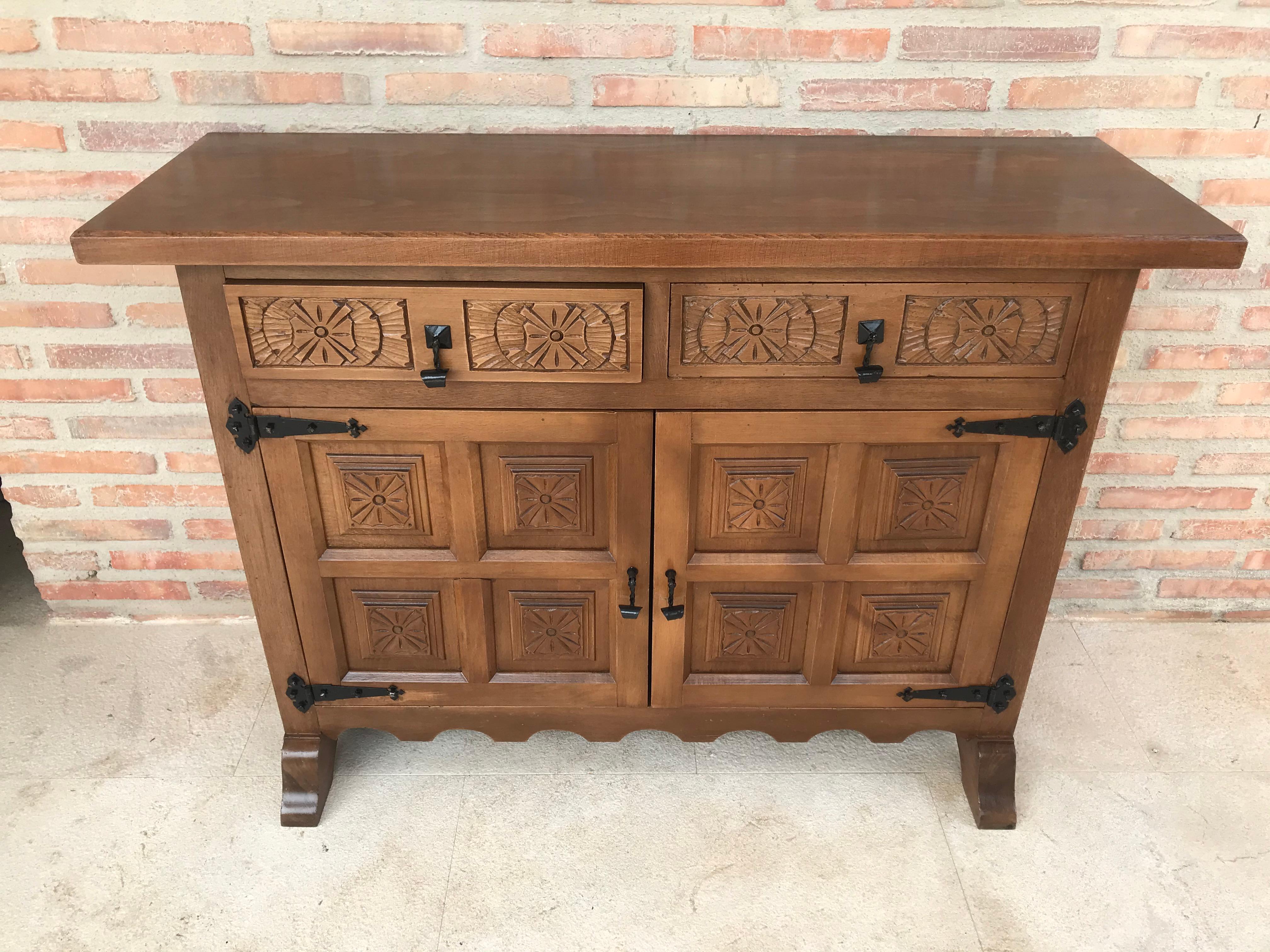From Northern Spain, constructed of solid walnut, the rectangular top with molded edge atop a conforming case housing two drawers over two doors, the doors paneled with solid walnut, raised on a plinth base.

  