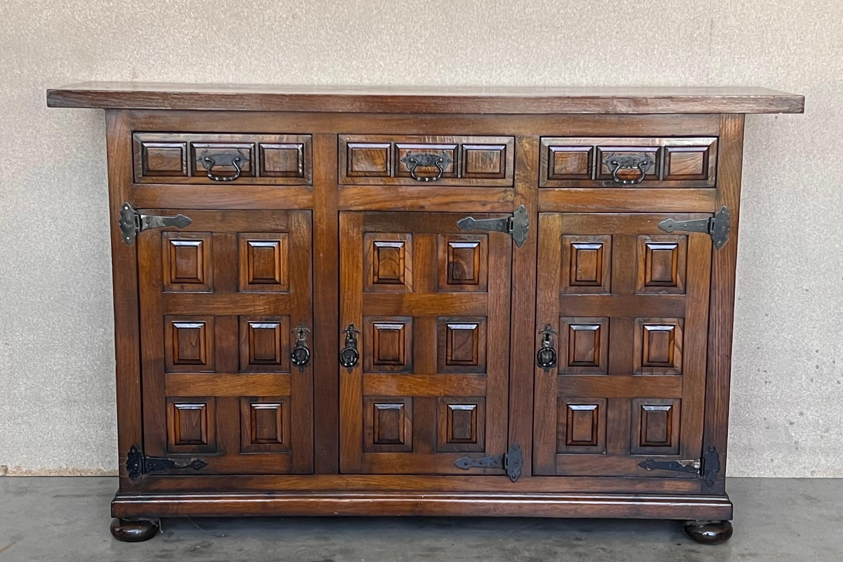 From Spain, constructed of solid walnut, the rectangular top without edge top, conforming case housing two carved drawers with two doors paneled with solid walnut, raised on a plinth base.
Very heavy and original cabinet.