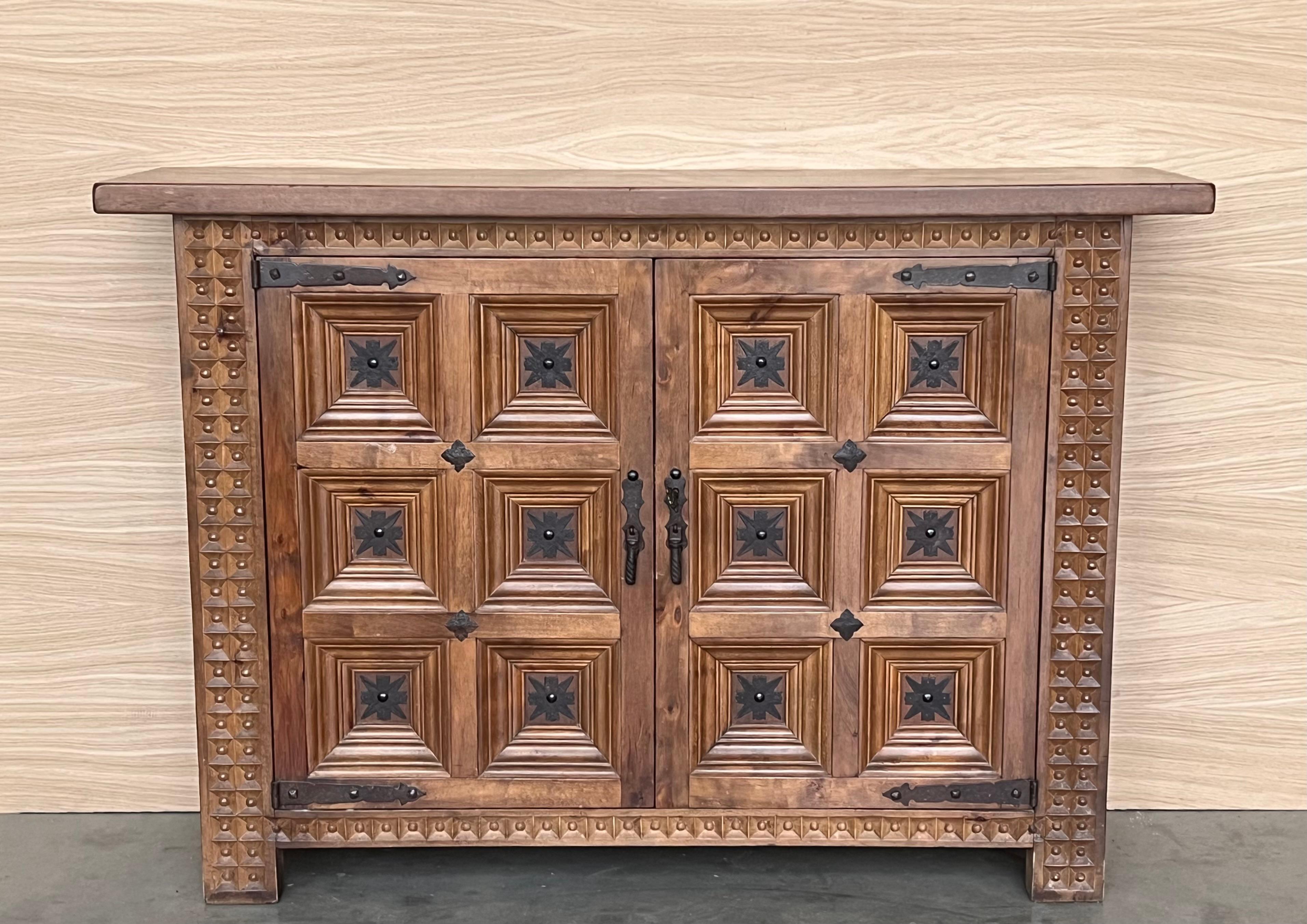 From Spain, constructed of solid oak, the rectangular top without edge top, conforming case housing two carved and paneled heavy doors with solid oak, raised on a plinth base.
Very heavy and original cabinet.
Original hardware