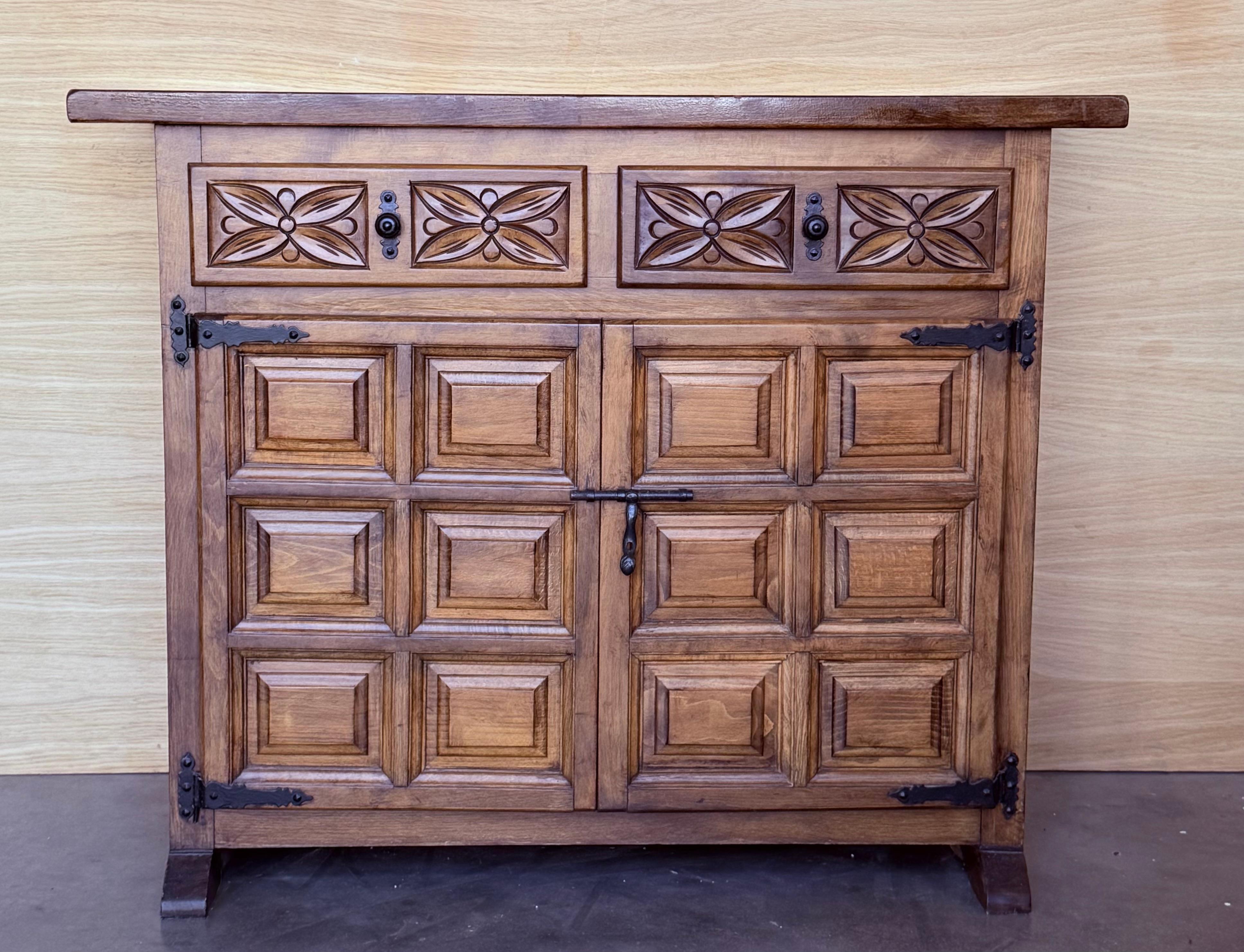 20th Century Catalan Spanish Carved Walnut Chest of Drawers, Sideboard or Console, made from solid walnut and featuring two carved drawers, two charmingly detailed doors fitted with cast iron handles and large shelf, circa 1920s.